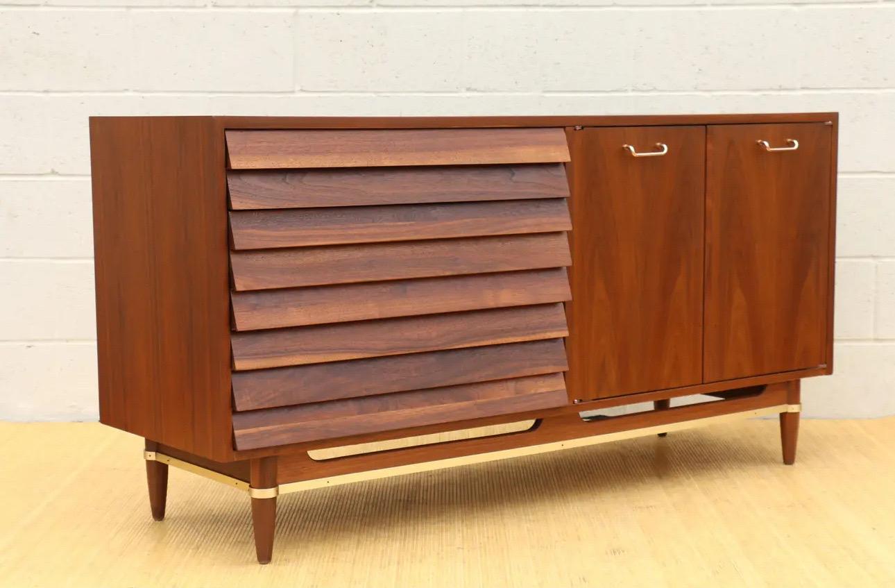 Beautiful credenza designed by Merton Gershun for American of Martinsville for the Dania collection, ( it has the label in the drawer. This nice credenza is made of solid walnut with great brass accent. Offers ample storage, it has six drawers and