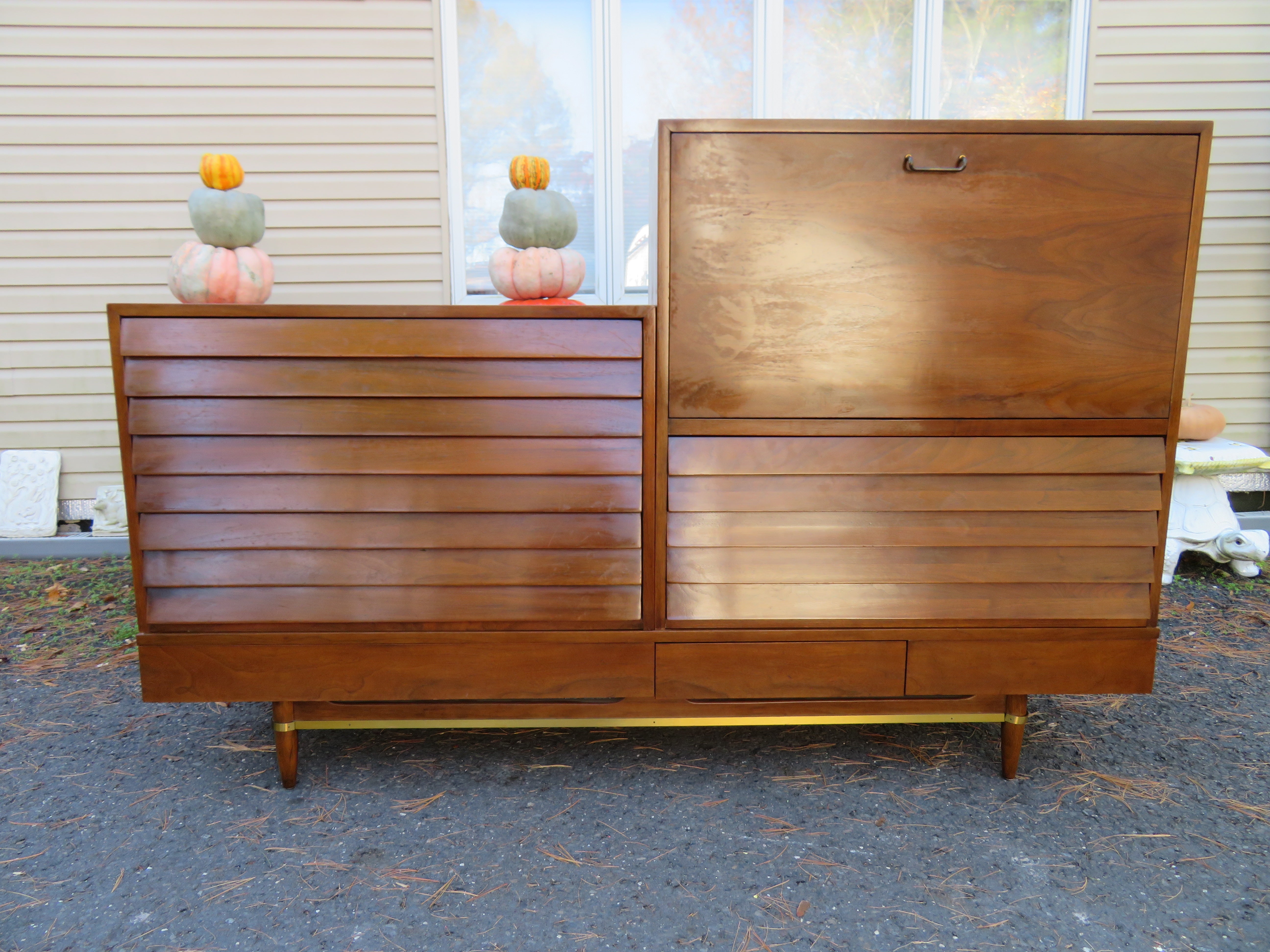 Mid-Century Modern walnut low bench with modular desk and drawer cabinet designed by Merton Gerhsun for American of Martinsville's Dania line circa 60s. The low bench has three drawers with brass accents on the legs and stretcher. We especially love