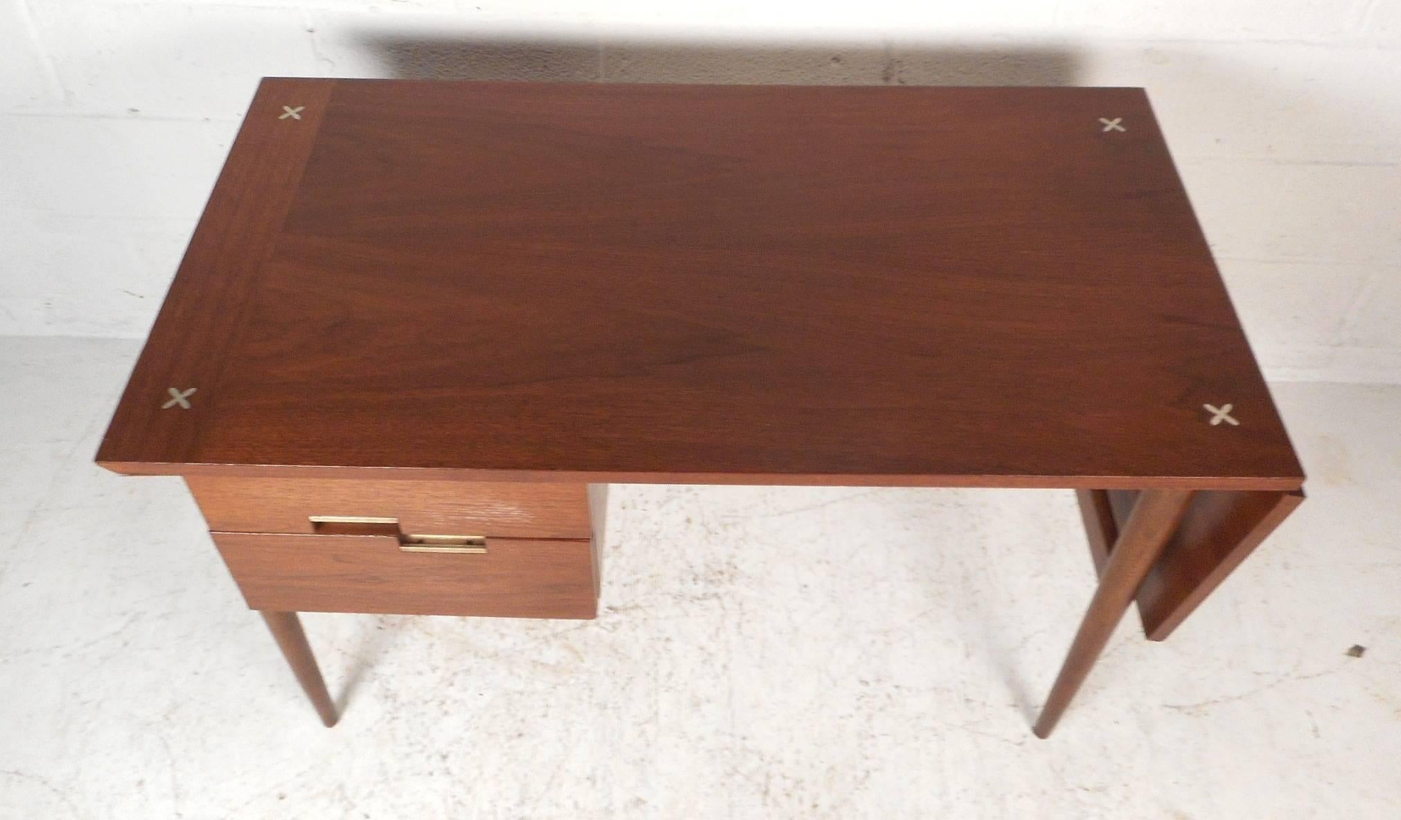This one of a kind Mid-Century Modern desk features a drop leaf on one side that extends the width of the top from 44 inches to 58 inches. A wonderful design with aluminum drawer pulls, a finished back, and lovely star inlays on the top of the desk.
