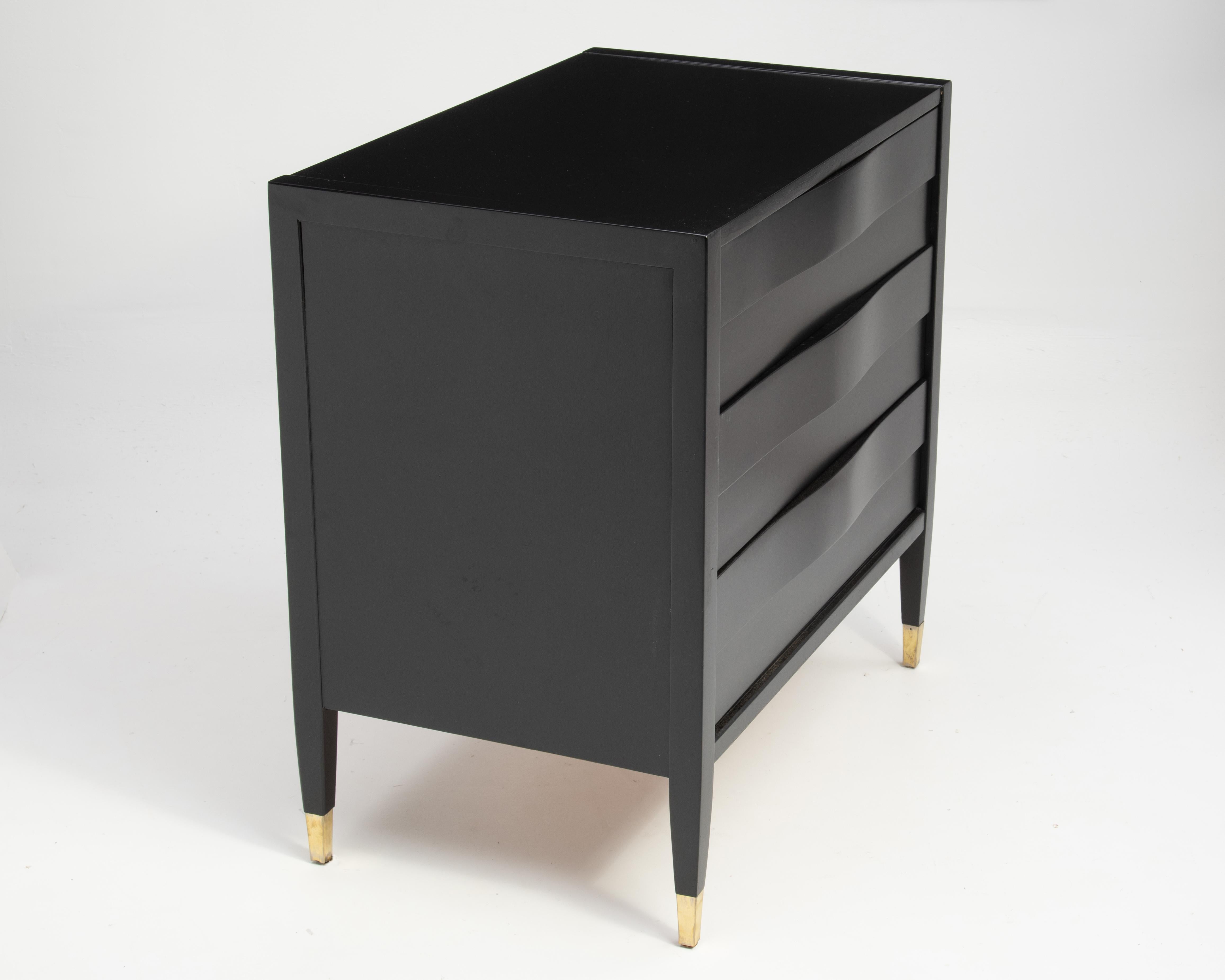 A very elegant American of Martinsville wavy front dresser or chest refinished in black lacquer with original brass feet. The drawer pulls are hidden under the wave. After the designs of Edmond Spence. A very useable piece...
