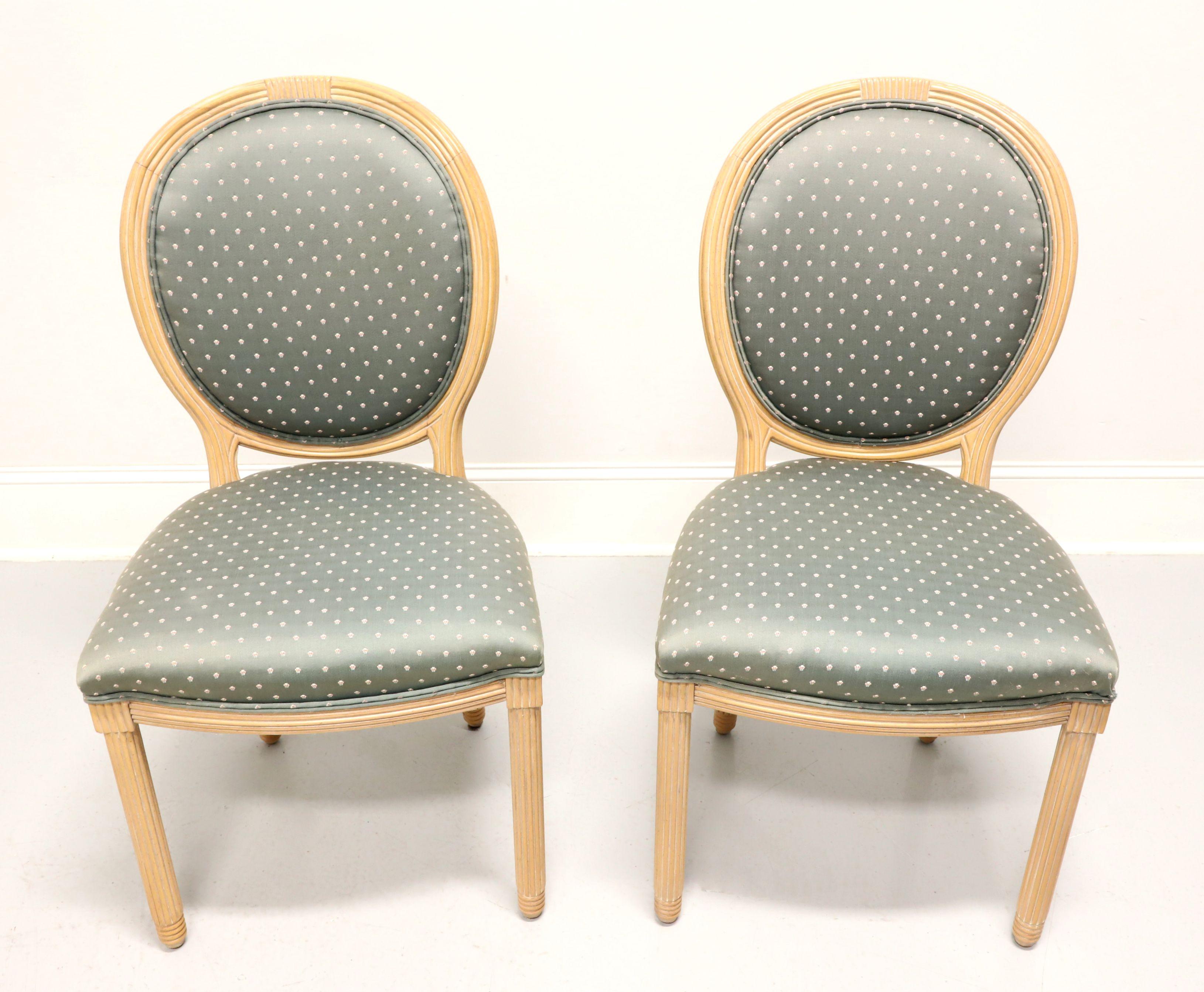 A pair of French Provincial Louis XVI style dining side chairs by American of Martinsville. Solid hardwood with a whitewashed & slightly antiqued finish, decoratively fluted oval back, sage green color fabric upholstered back & seat, fluted apron,