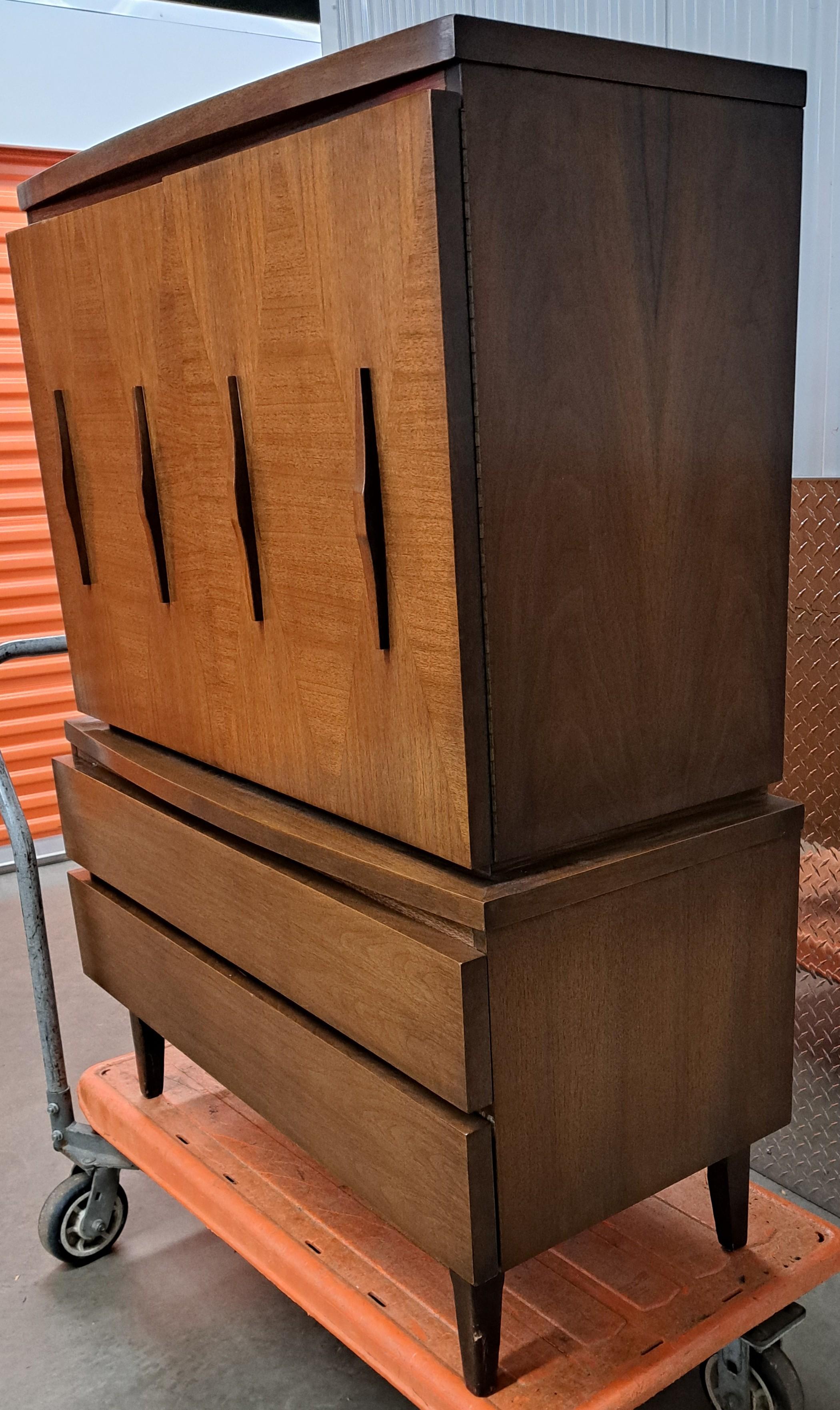 Classico American of Martinsville con motivo a diamante. Il comò ha tre cassetti nella parte superiore con ante e due cassetti nella parte inferiore. Si erge su gambe di legno.