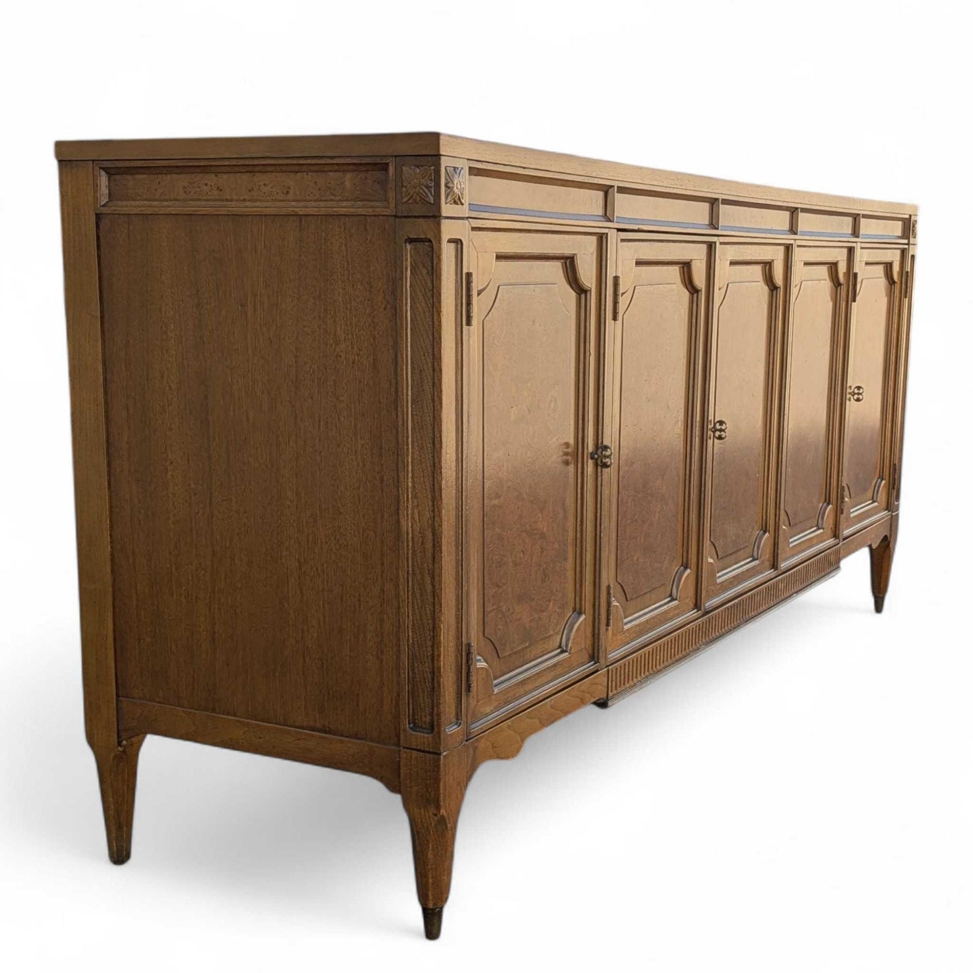 A rare and refined “Tribune” credenza by American of Martinsville, circa late 1950s to early 1960s.

This exceptional buffet showcases the brand’s craftsmanship at its peak, featuring a solid oak frame accented by walnut burl inlaid panels and