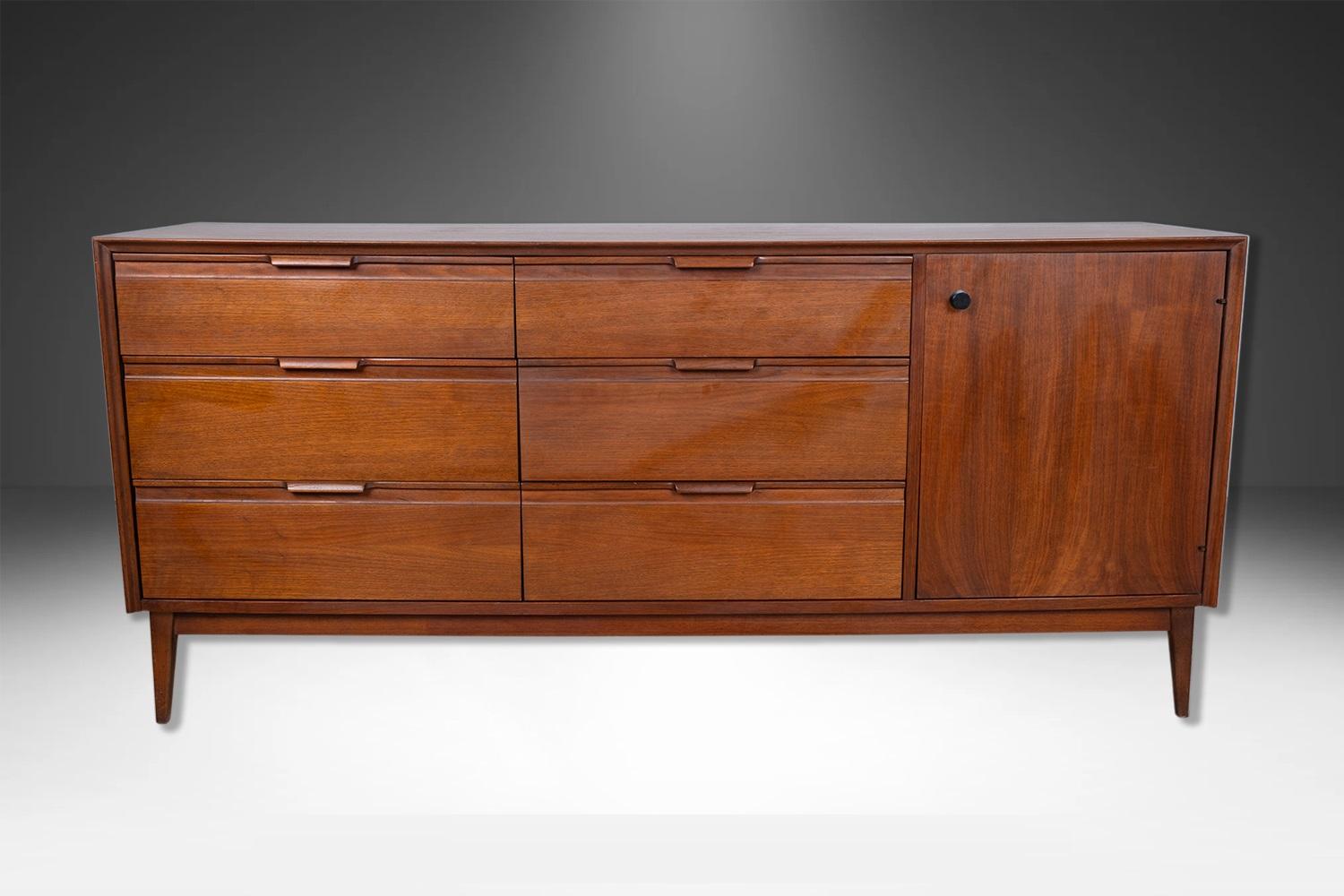 Beautifully detailed walnut American of Martinsville 9 Drawer dresser in great condition. Featuring a rectangular top over a single door cabinet on the right side, which opens to reveal a storage compartment with three convenient white drawers,