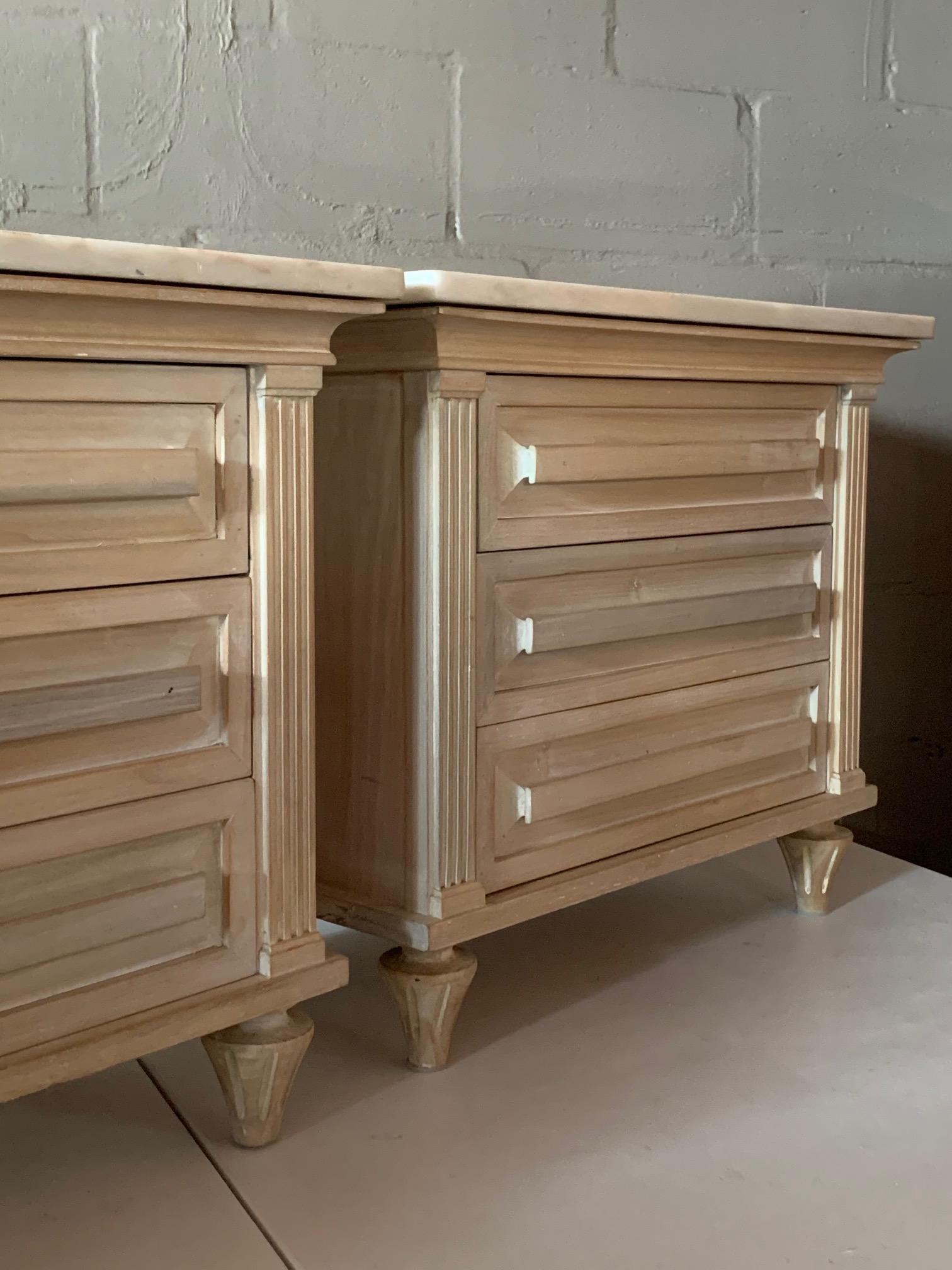 A pair of American of Martinsville nightstands with marble tops. Hollywood Regency stile with elegant, white wash finish.