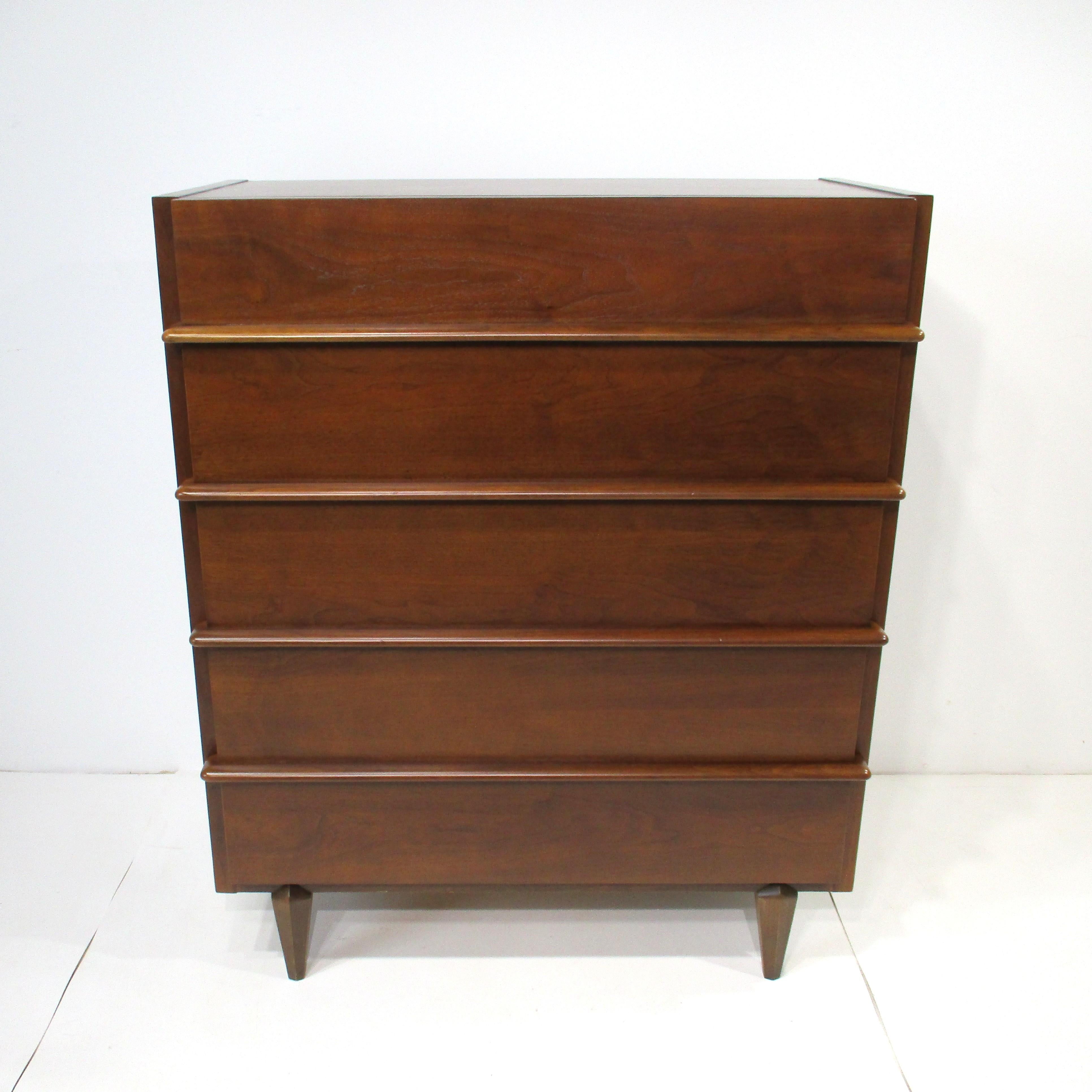 Un'eccezionale cassettiera highboy in noce di vecchia crescita con una grana molto ben definita. Questo bellissimo mobile a cinque cassetti è dotato di lunghi e scultorei tiranti nella parte anteriore e il cassetto superiore ha due divisori, il