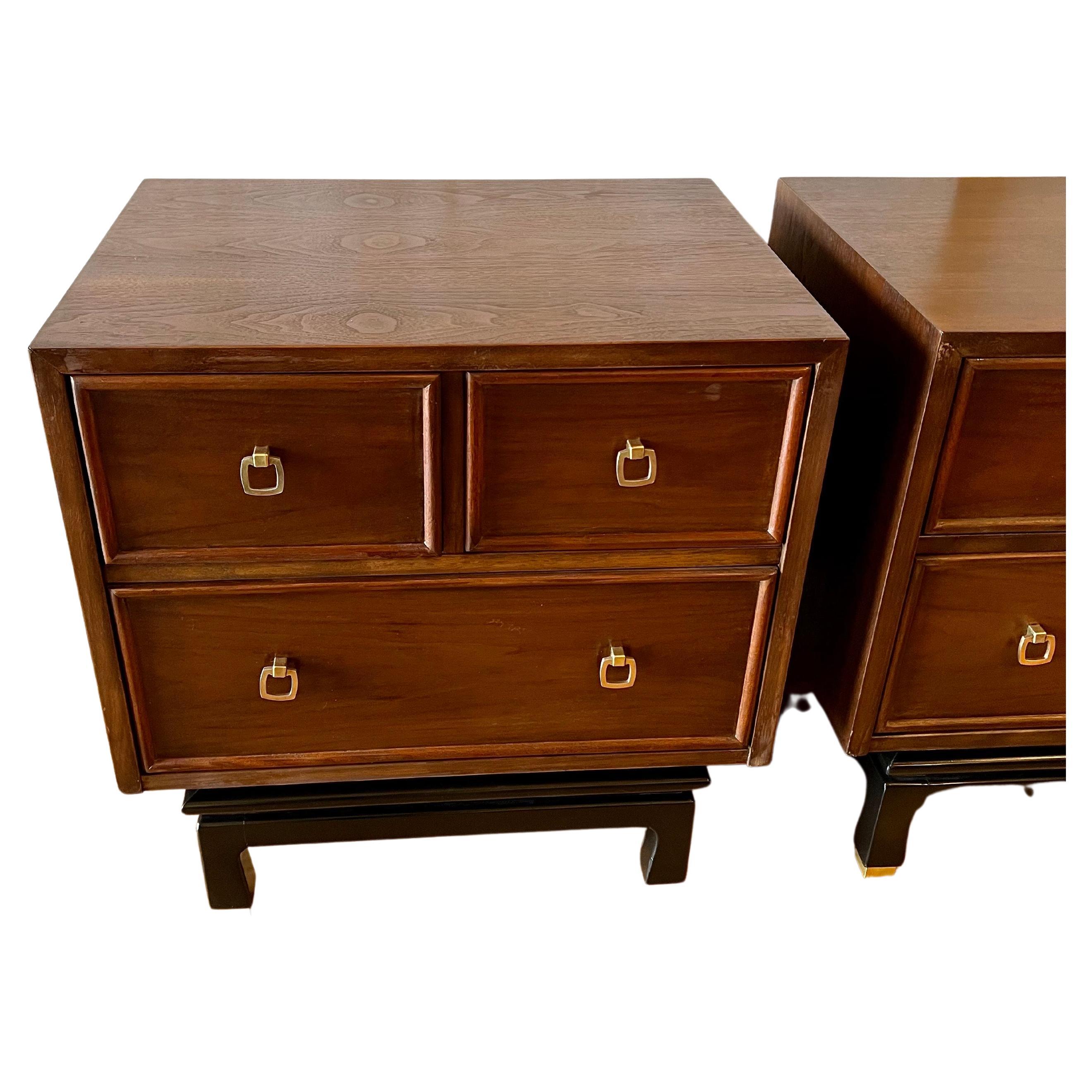 Beautiful elegant Mid-Century Modern pair of nightstands by American of Martinsville, circa 1960s freshly refinished in a walnut finish with black lacquered base and polished brass handles and legs tips, very clean and nice condition.