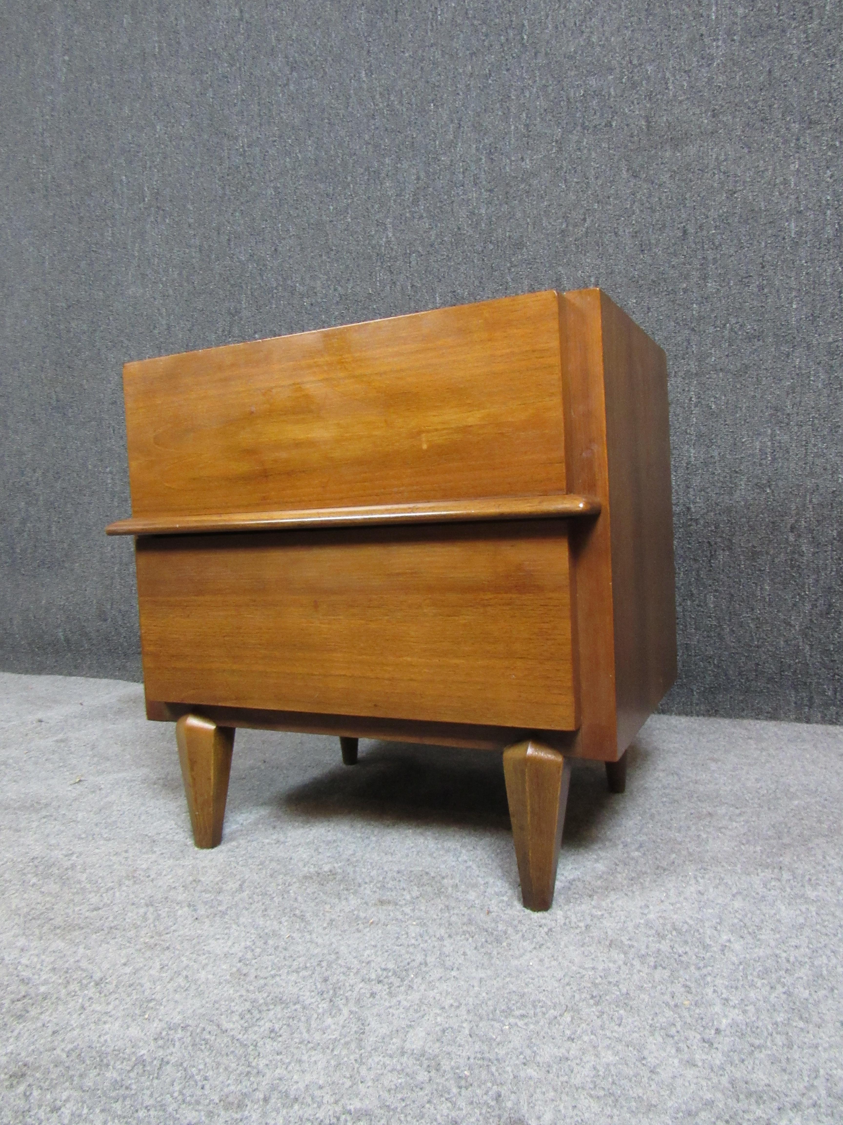 Fantastic single mid-century nightstand from the renowned furniture builders at American of Martinsville. Featuring a chunky, almost primitive design, the broad structure highlights a mesmerizing walnut grain. Two ample drawers provide plenty of