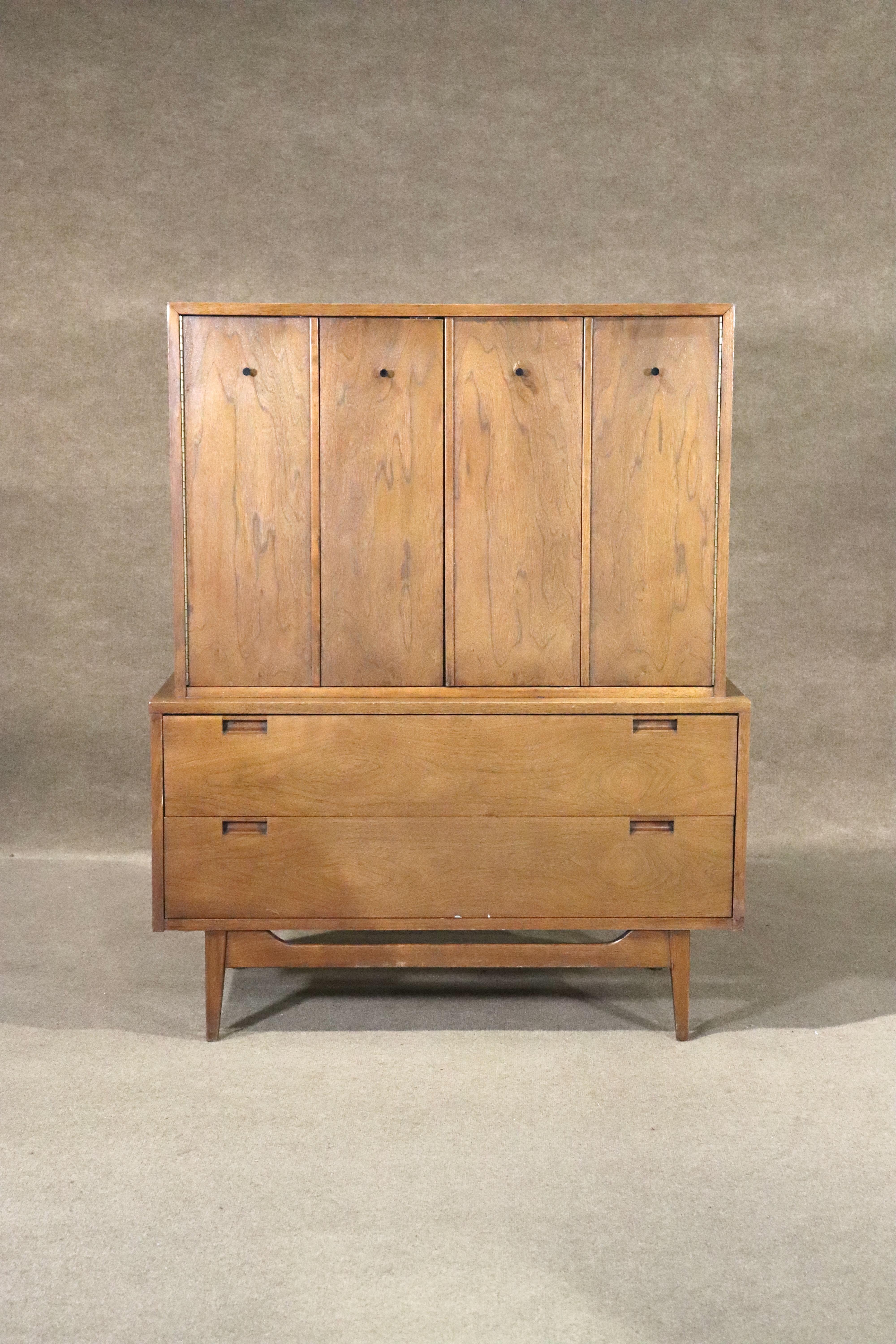 Mid-century armoire style dresser by American of Martinsville. Walnut wood grain throughout with accenting black hardware. Five wide drawers for bedroom storage.
Please confirm location NY or NJ