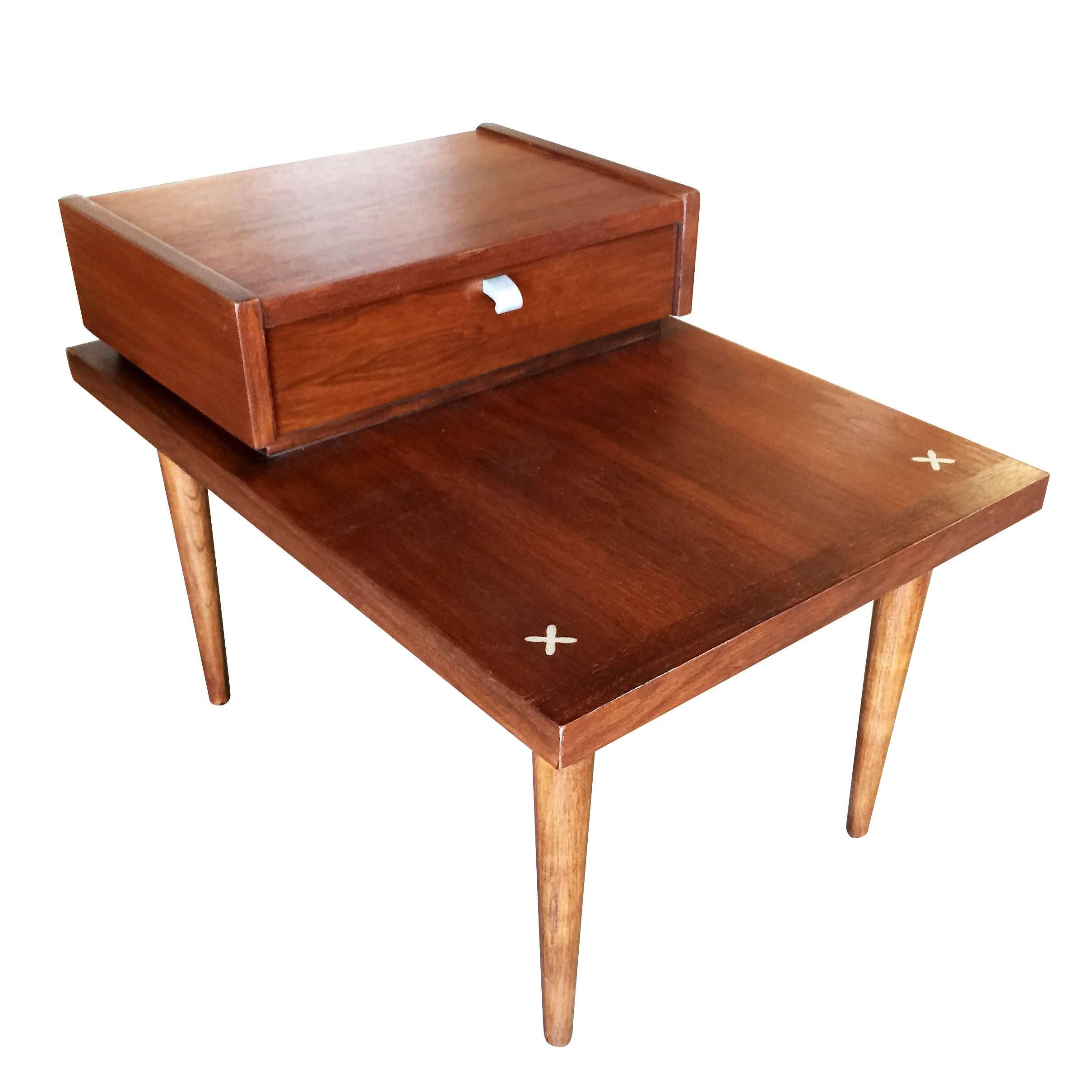 American of Martinsville two-tier bedside tables in the style of Geroge Nelson with top pull-out drawer and X-shaped metal inlays, circa 1950.

Signed 