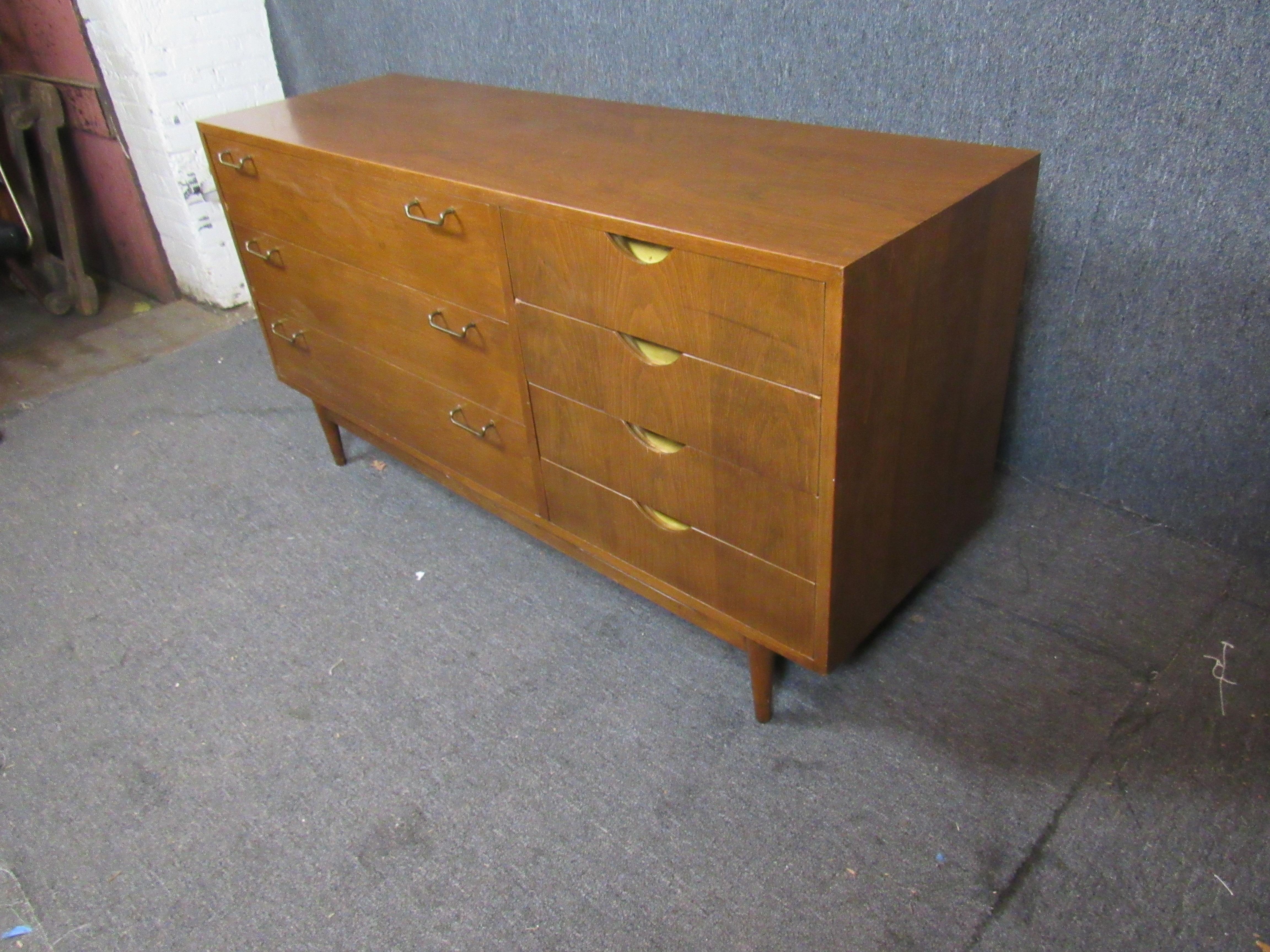 Beautiful and practical mid-century vintage sideboard from the world-renowned American of Martinsville furniture makers. Seven large pull-out drawers offer plenty of storage space, for the home or office. A rich walnut wood grain pairs perfectly