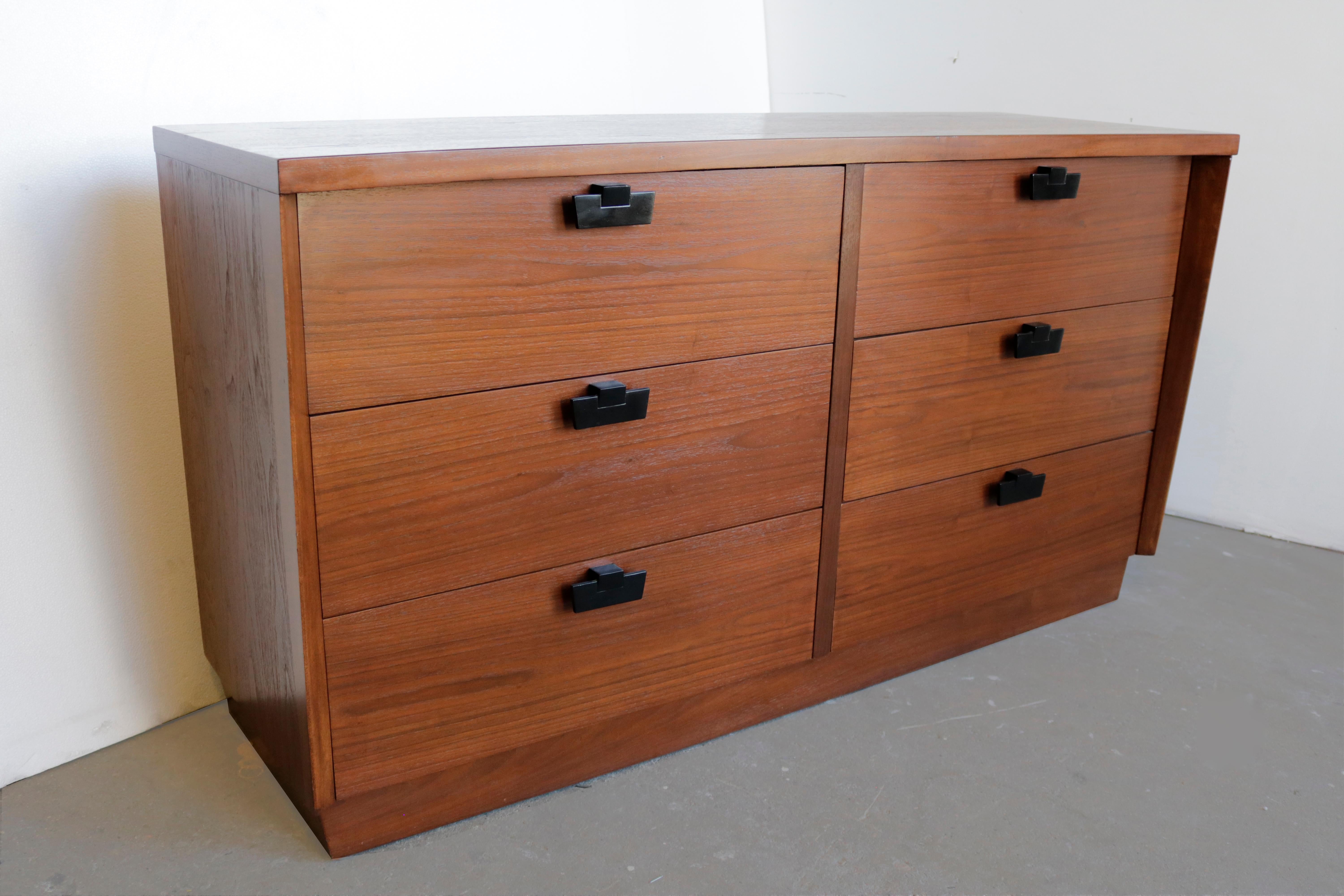 This dresser made of walnut features six drawers with black painted metal pulls.
Very interesting lines and like always with American of Martinsville pieces very high-quality craftsmanship.