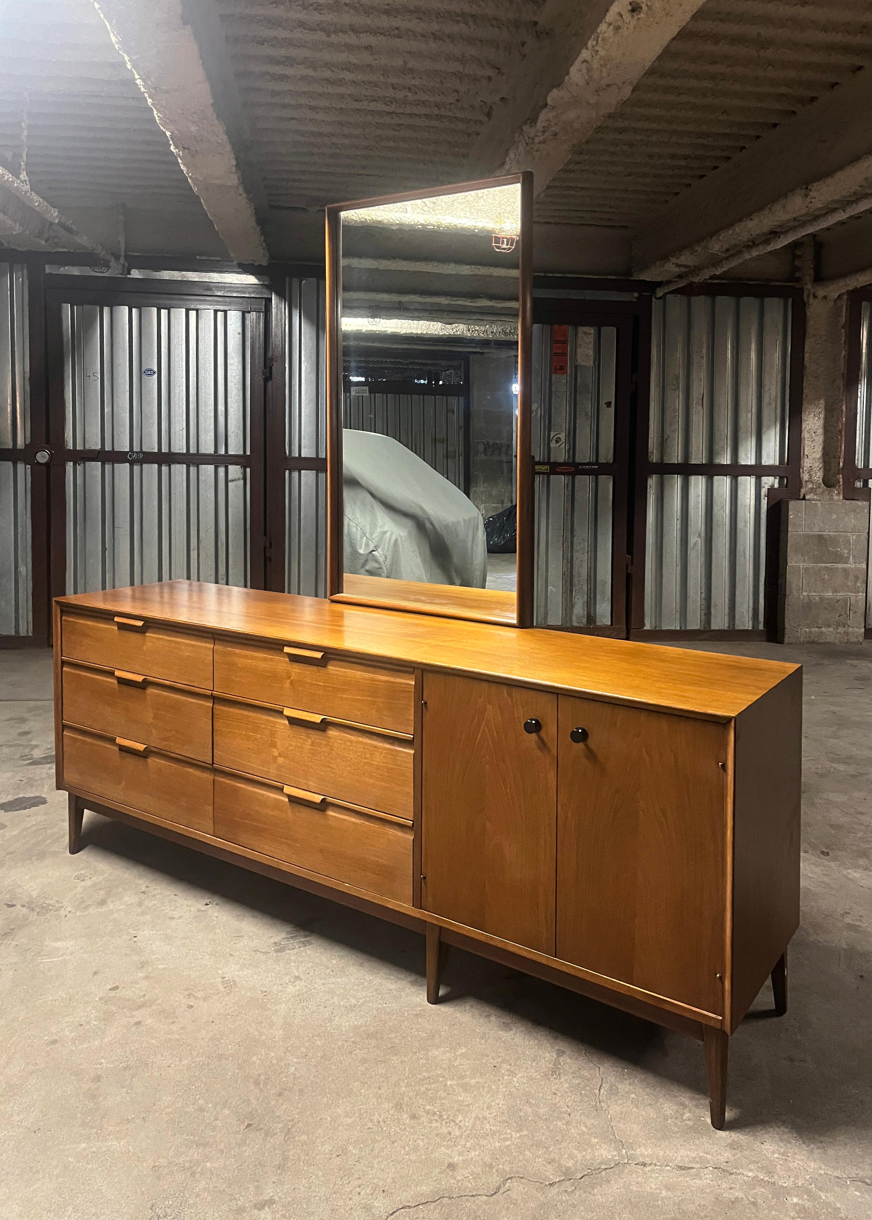 Bedroom storage galore! American of Martinsville walnut long dresser credenza with attached mirror. 6 drawers on the left side and double doors on the right that reveal 3 more beautifully outfitted drawers. Very clean modern lines, solid wood pulls,