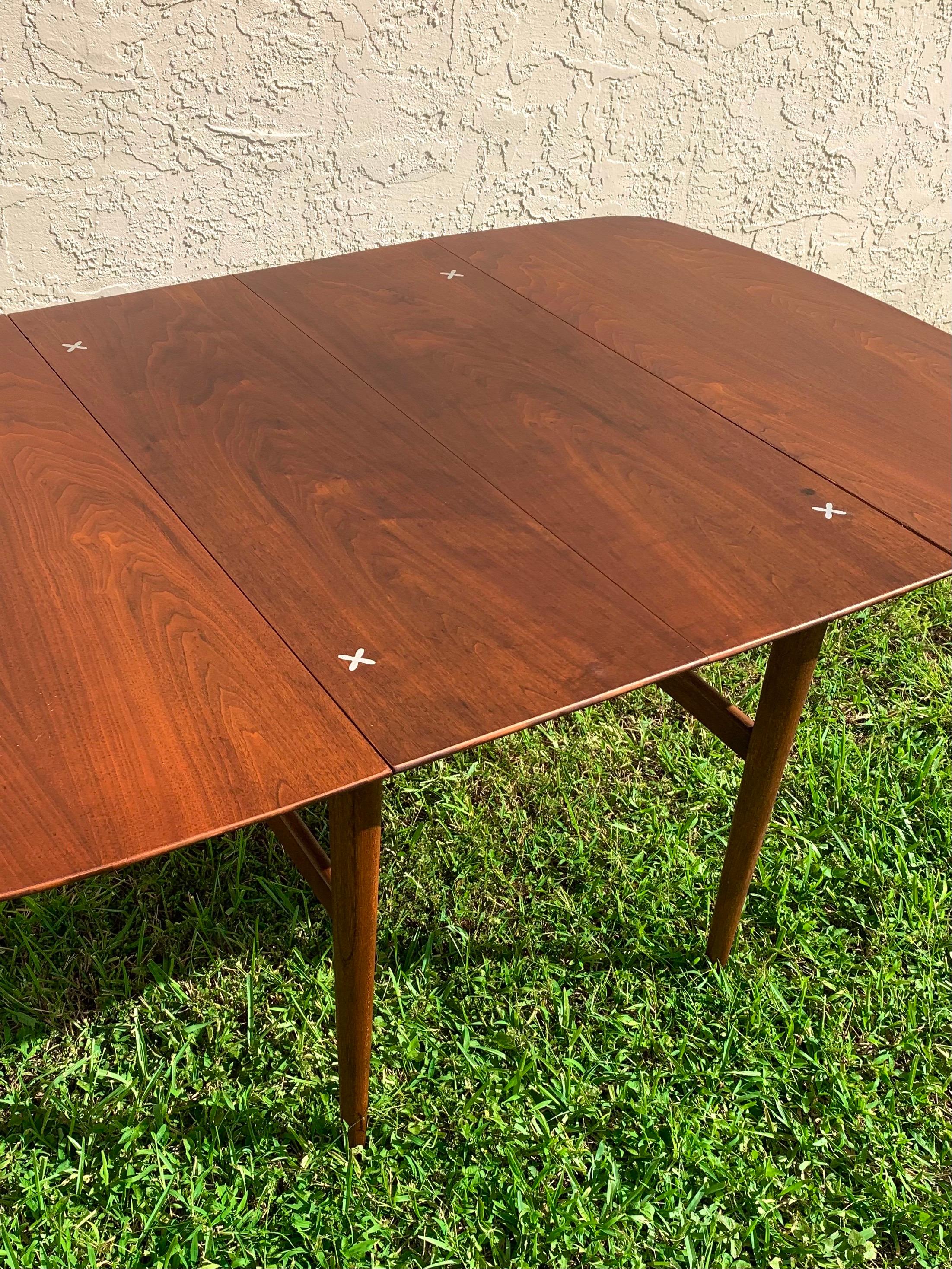 Mid-Century Modern dining table designed by Merton Gershun for American of Martinsville Dania line. Drop leaf design with 2 leaves. Top refinished. Able to go from a 25” table top to an 85” table top to fit all dining needs. 

7.5/10 condition due