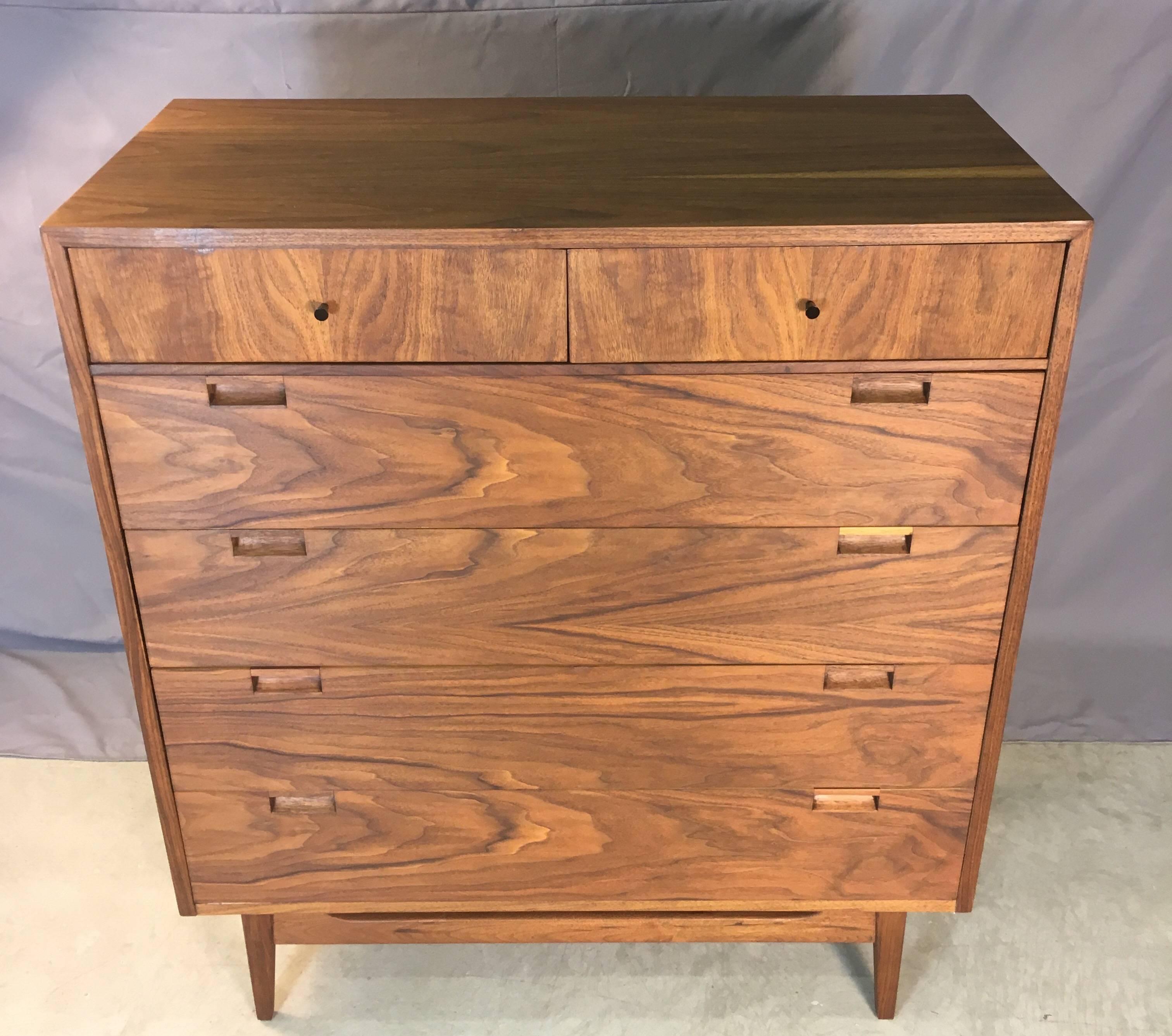 Vintage 1960s tall walnut dresser by American of Martinsville. The dresser has six drawers for storage and black metal pulls. Marked. In refinished condition.