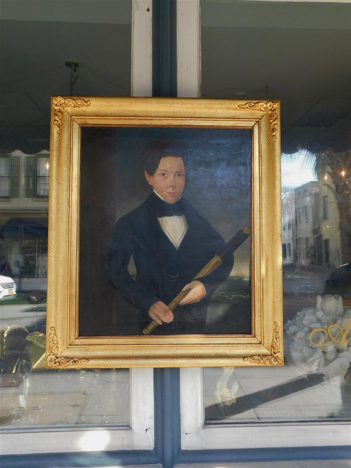 American portrait oil on canvas of a young ship captain holding a spyglass with a sailing ship, crew in rowboat, and gulls in lower background mounted in the original decorative gilt honeycomb floral frame, Mid-19th century.