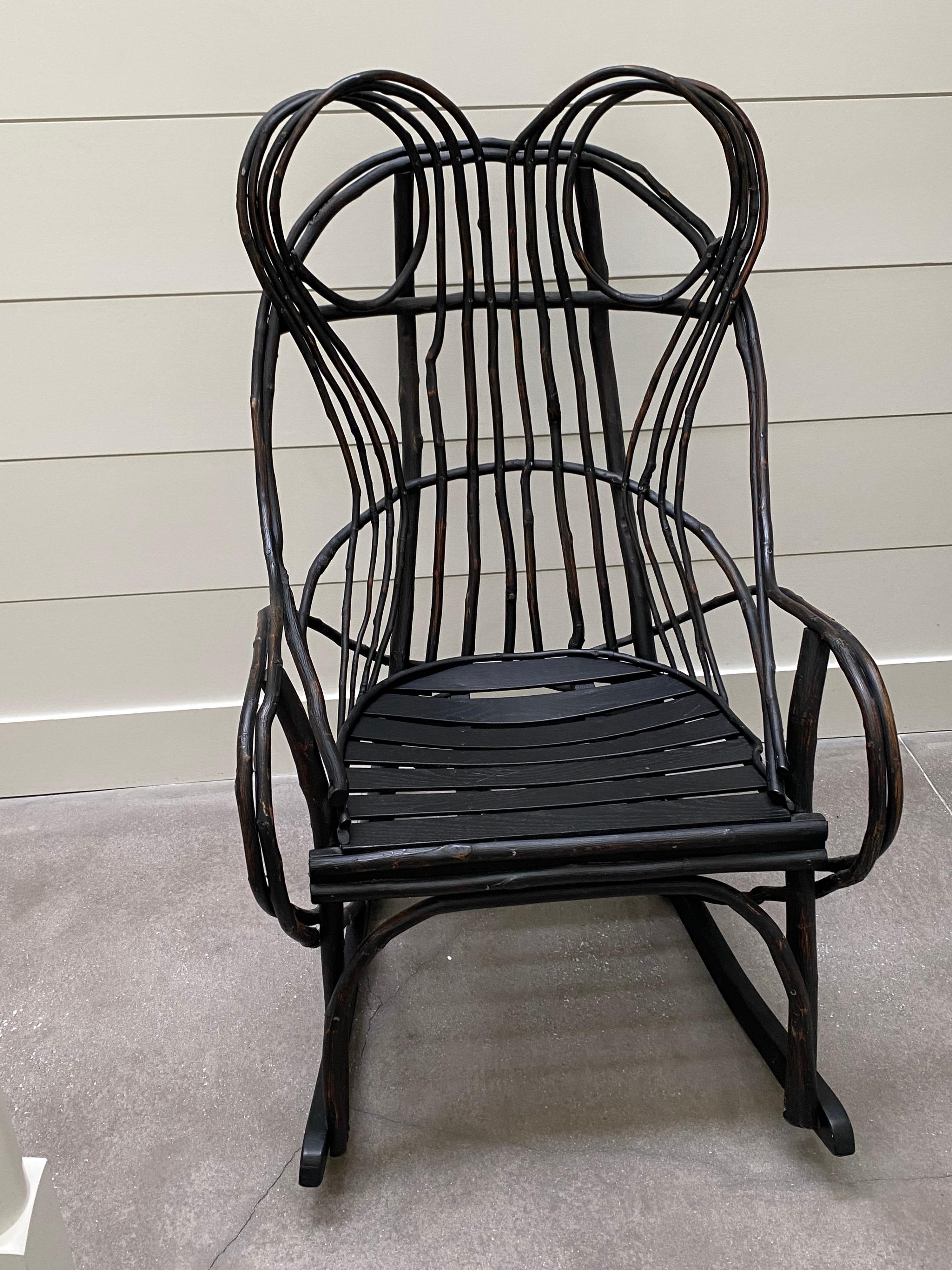 American painted Adirondack twig rocking chair, custom made in the Adirondacks, New York, in the past 20 years. Painted in cool modern black. Light wear to arms mainly.
Measures: 23” arm height
43.5” high x 22.5” wide x 31” deep 
22” seat