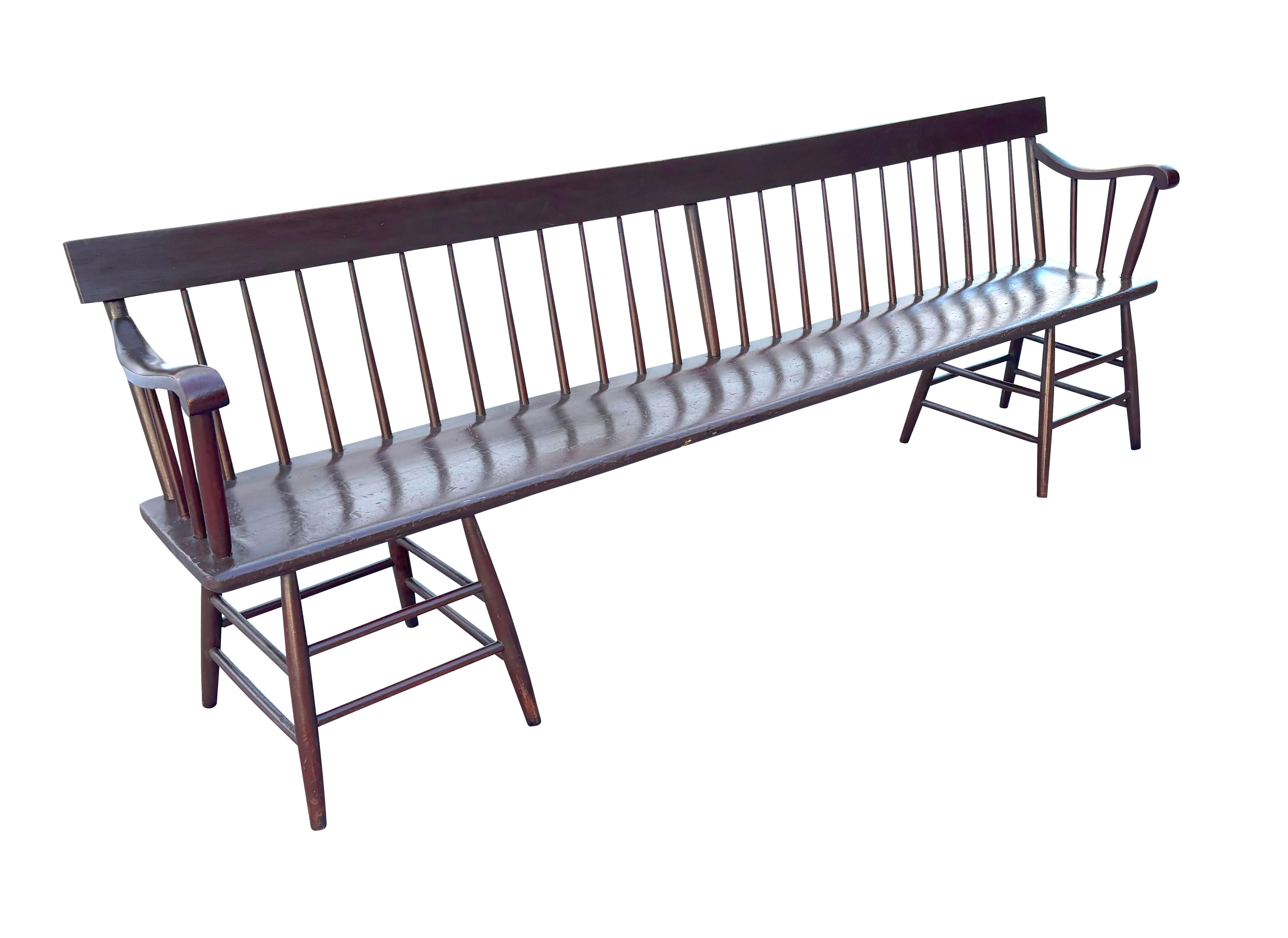 With brown paint. With rectangular crest rail over spindles and a conforming seat . Scroll arms. Turned legs. Very sturdy. 