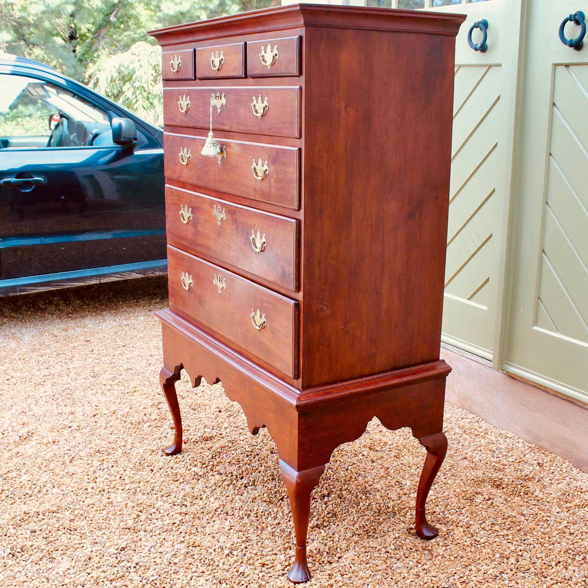 A very handsome antique American chest on frame with three (small) over four (large) drawer upper case with good figuring to the drawer fronts rests on a nicely contoured cabriolet leg frame with visible pegged construction. A moulded edge finishes