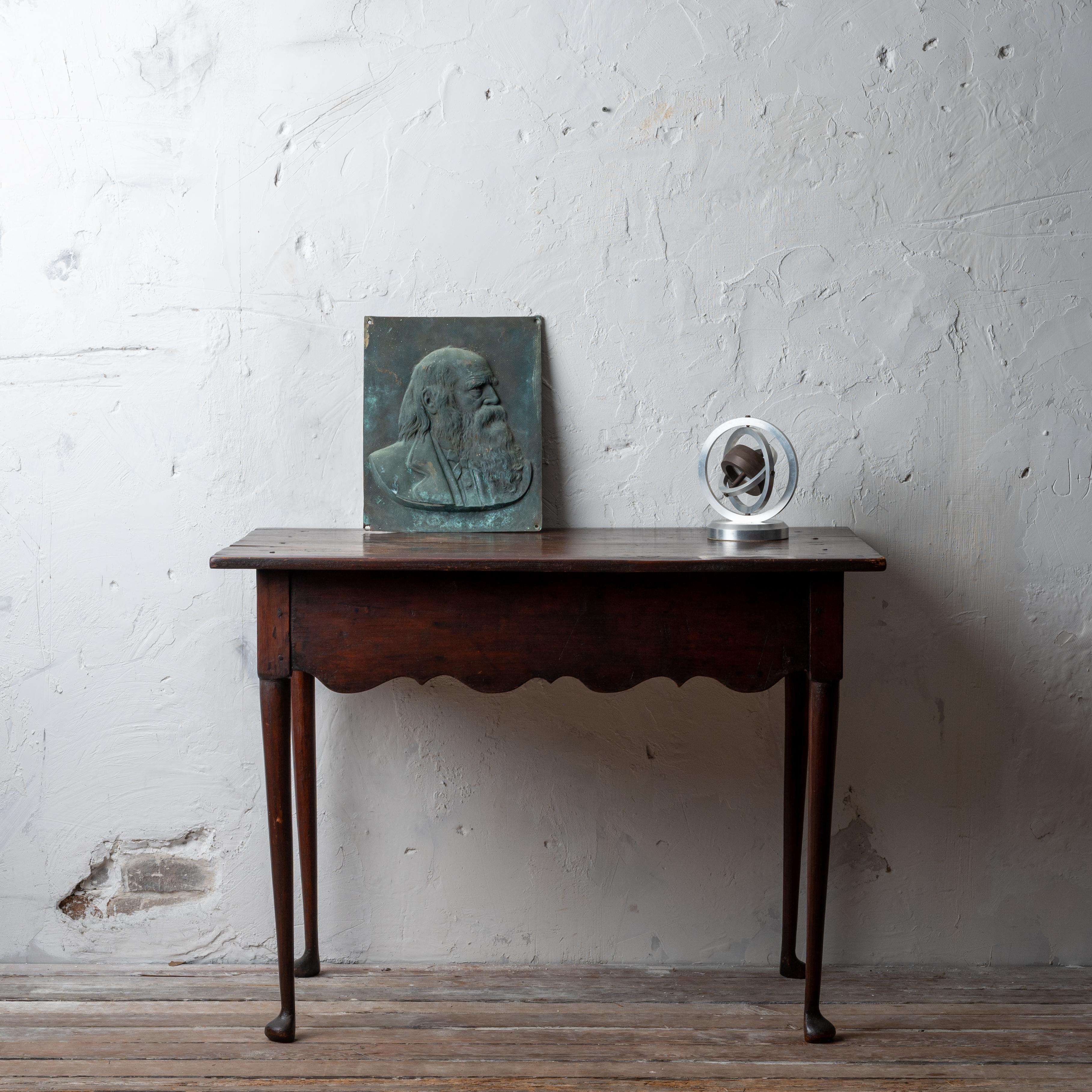 An American pine side table with scalloped apron and finely carved legs with pad feet, mid-18th century.



39 ½ inches wide by 23 ¼ inches deep by 29 ½ inches tall



