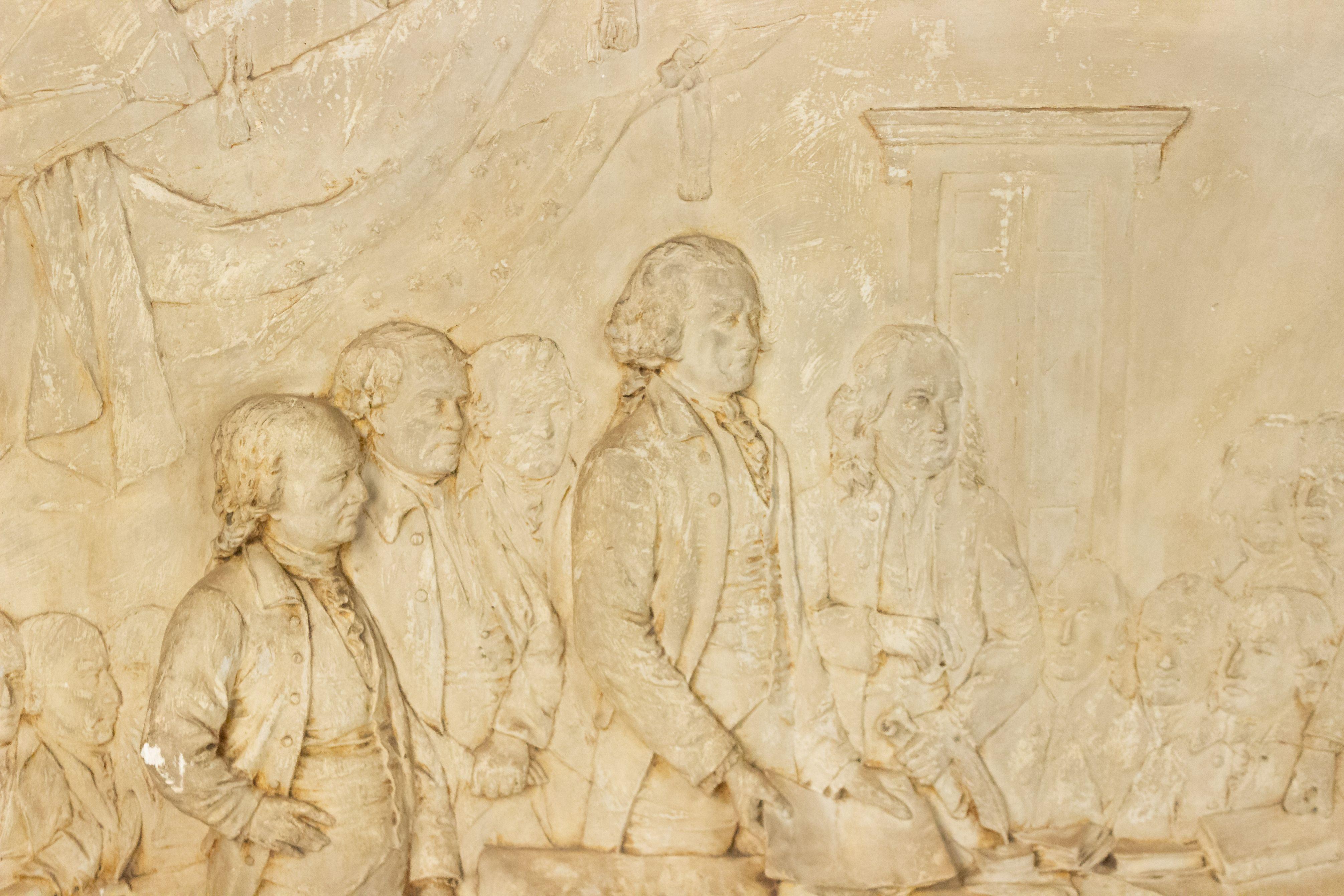 American country tinted plaster cast relief of the signing of the Declaration of Independence (signed: A. PENNUCI/ROSLAN Mass.).
 