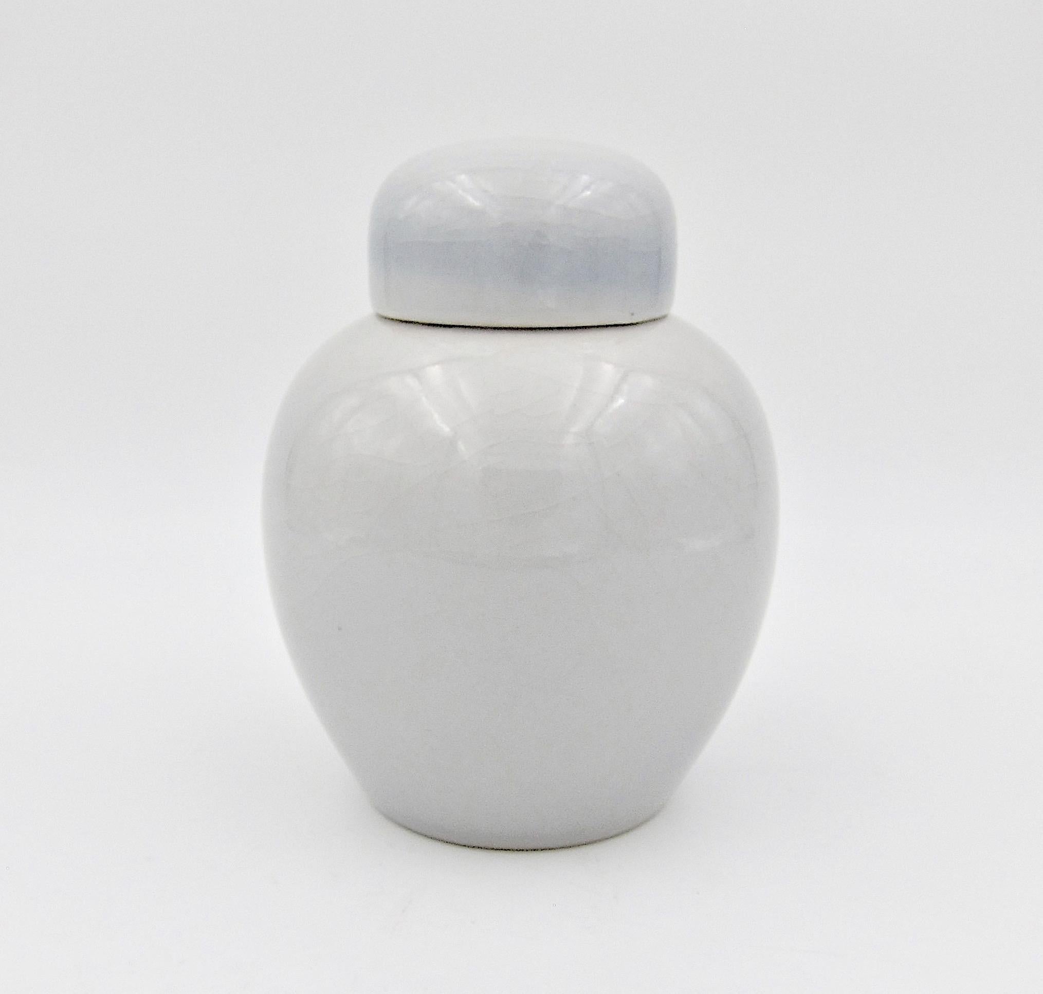 An American porcelain ginger jar by mid-20th century ceramicist Rodney Rouse (1903-1977) of Trenton, New Jersey, dating circa 1965-1970. The lidded vessel is decorated with a crisp, glossy glaze of pale gray with a hint of darker blue-gray