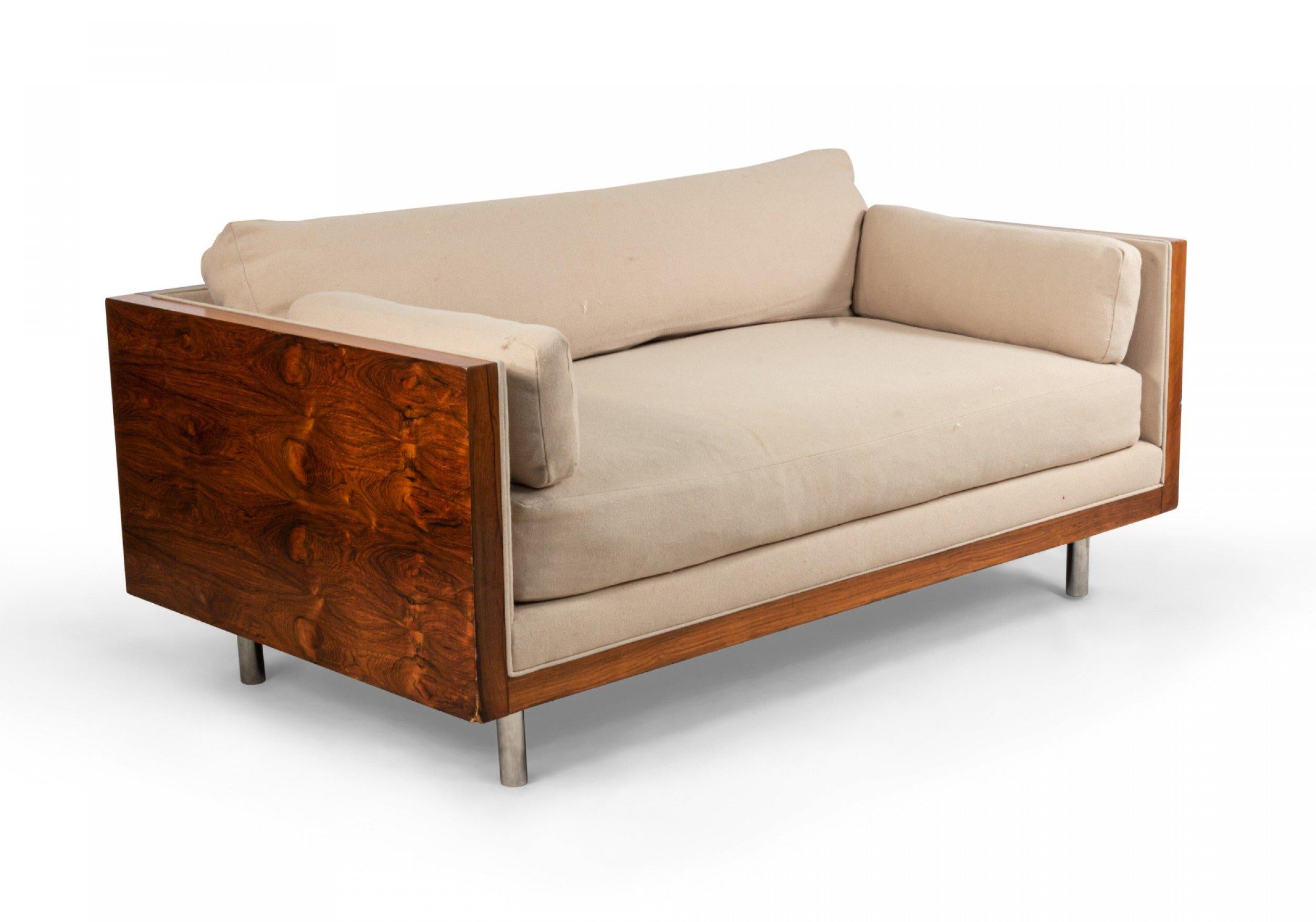 American Post-War design rosewood loveseat with chrome trim on cylindrical feet  having light beige upholstery (designed by MILO BAUGHMAN)