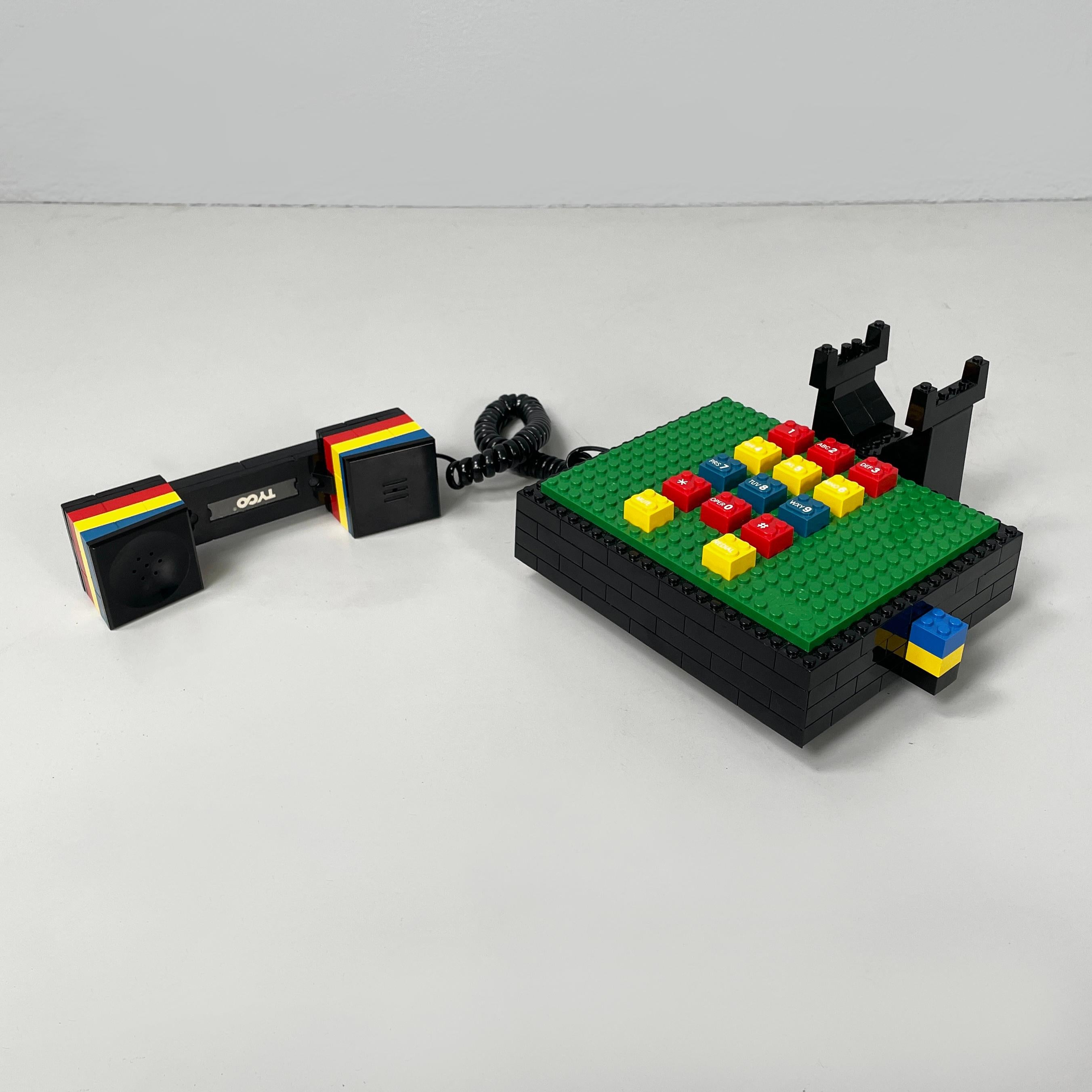 Téléphone de bureau postmoderne en plastique Lego de Tyco, années 1990
Téléphone de bureau entièrement construit avec des pièces de Lego en plastique coloré. Le combiné noir comporte 3 lignes décoratives en rouge, jaune et bleu. Le clavier est vert