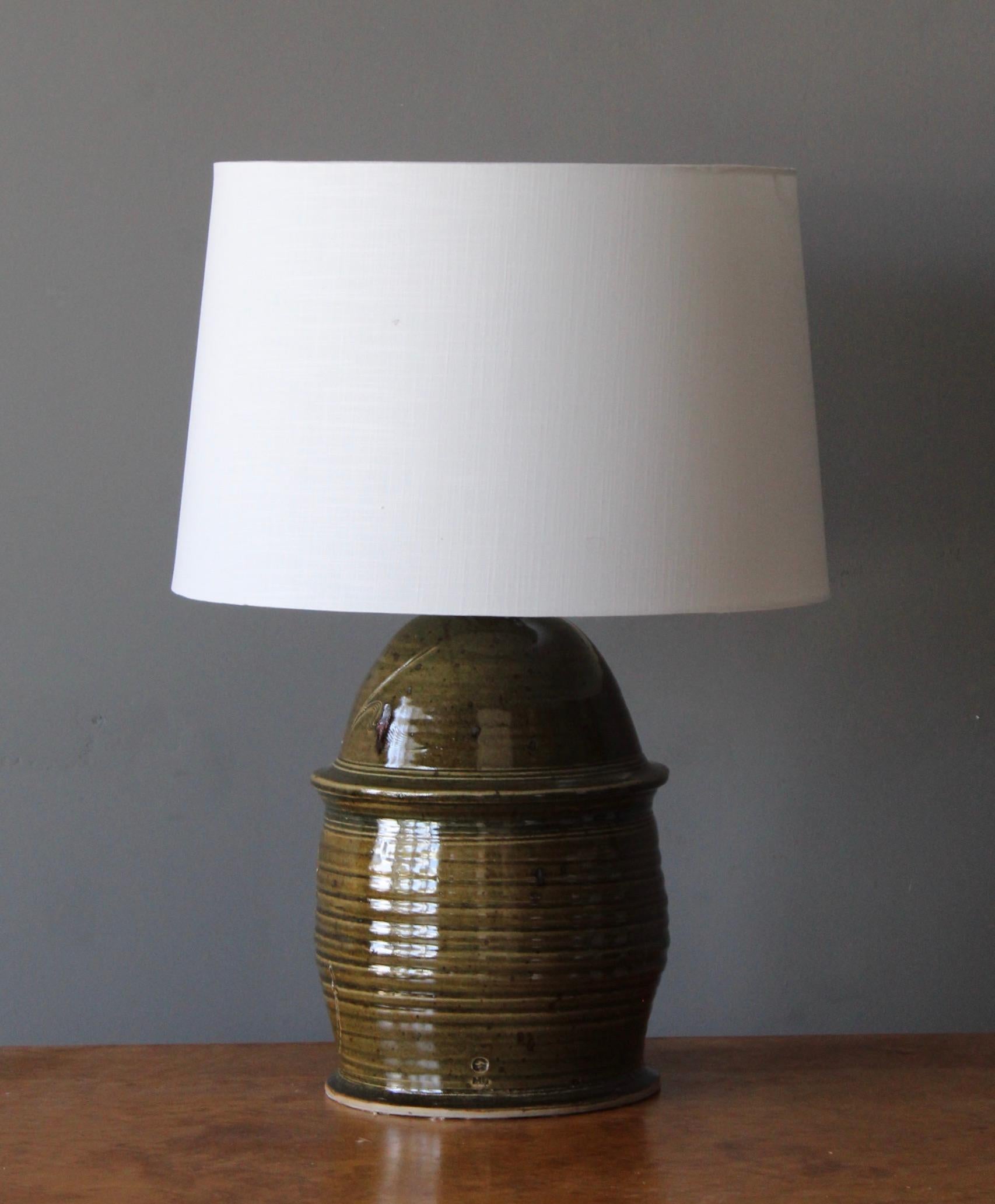 A sizable table lamp in ceramic. Designed and produced in United States, 1950s-1960s. Form is enhanced by incised artistic details

Sold without lampshade. Dimensions exclude lampshade height includes socket.