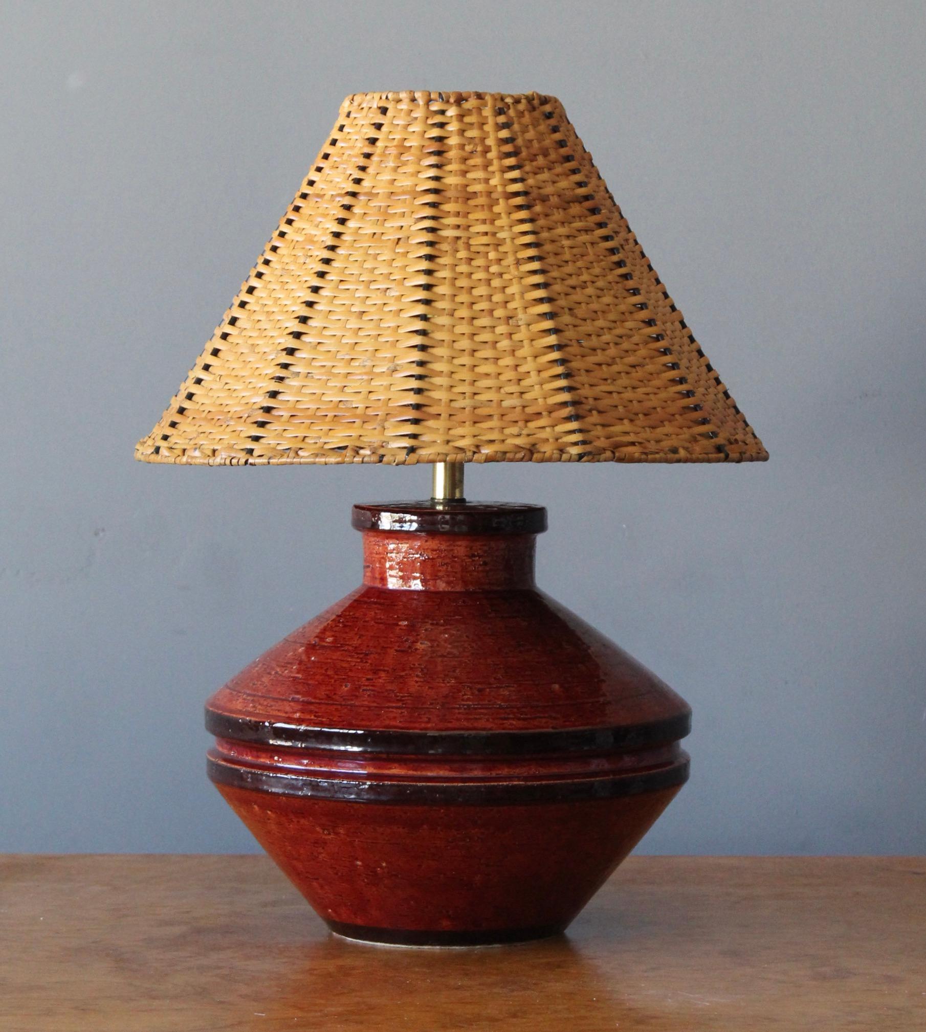 A table lamp in ceramic. Designed and produced in United States, 1950s-1960s. With an assorted rattan vintage lampshade.

Dimensions stated include lampshade as is illustrated.