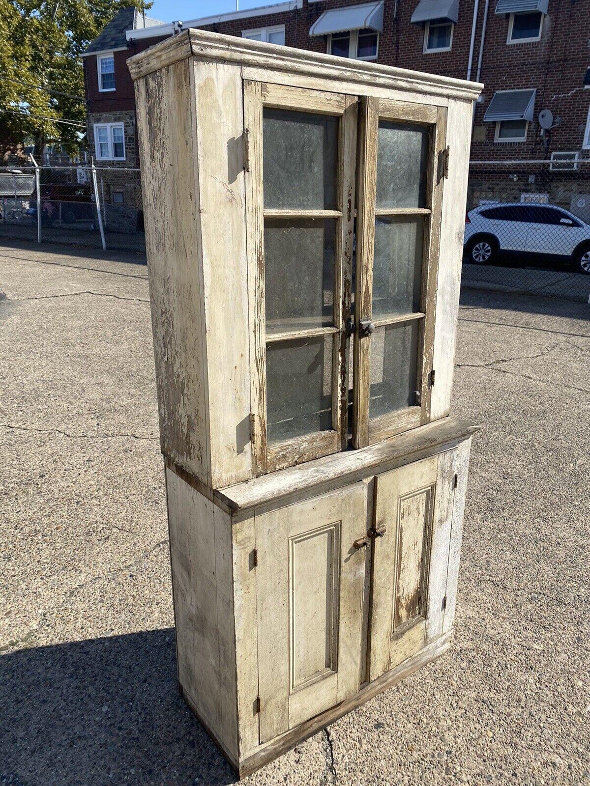 Antique American primitive country white distress painted pantry cupboard hutch cabinet. Item features 6 individual panes of glass to doors. Solid wood construction, distressed finish, 2 part construction, 2 wooden shelves. Circa 19th century.