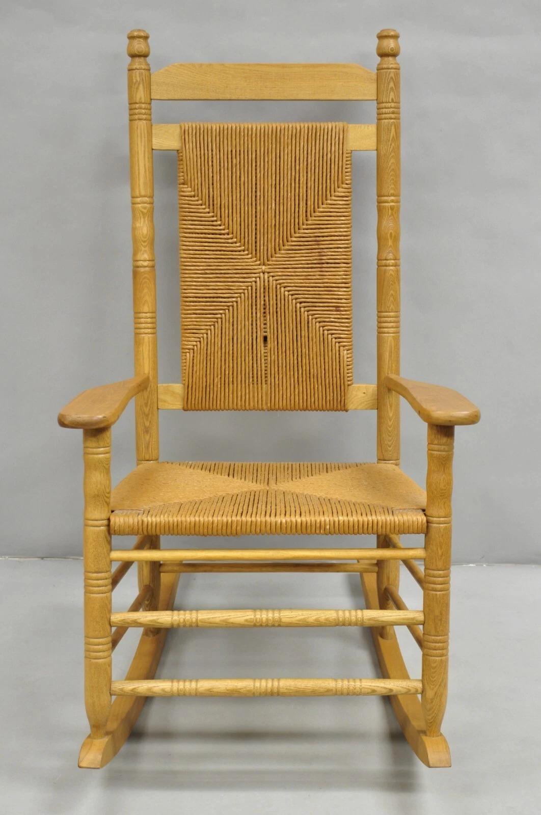 American Primitive Rustic Oak Wood Rush Seat Rocking Chair by Cracker Barrel. Circa Late 20th Century. Measurements: 46.5