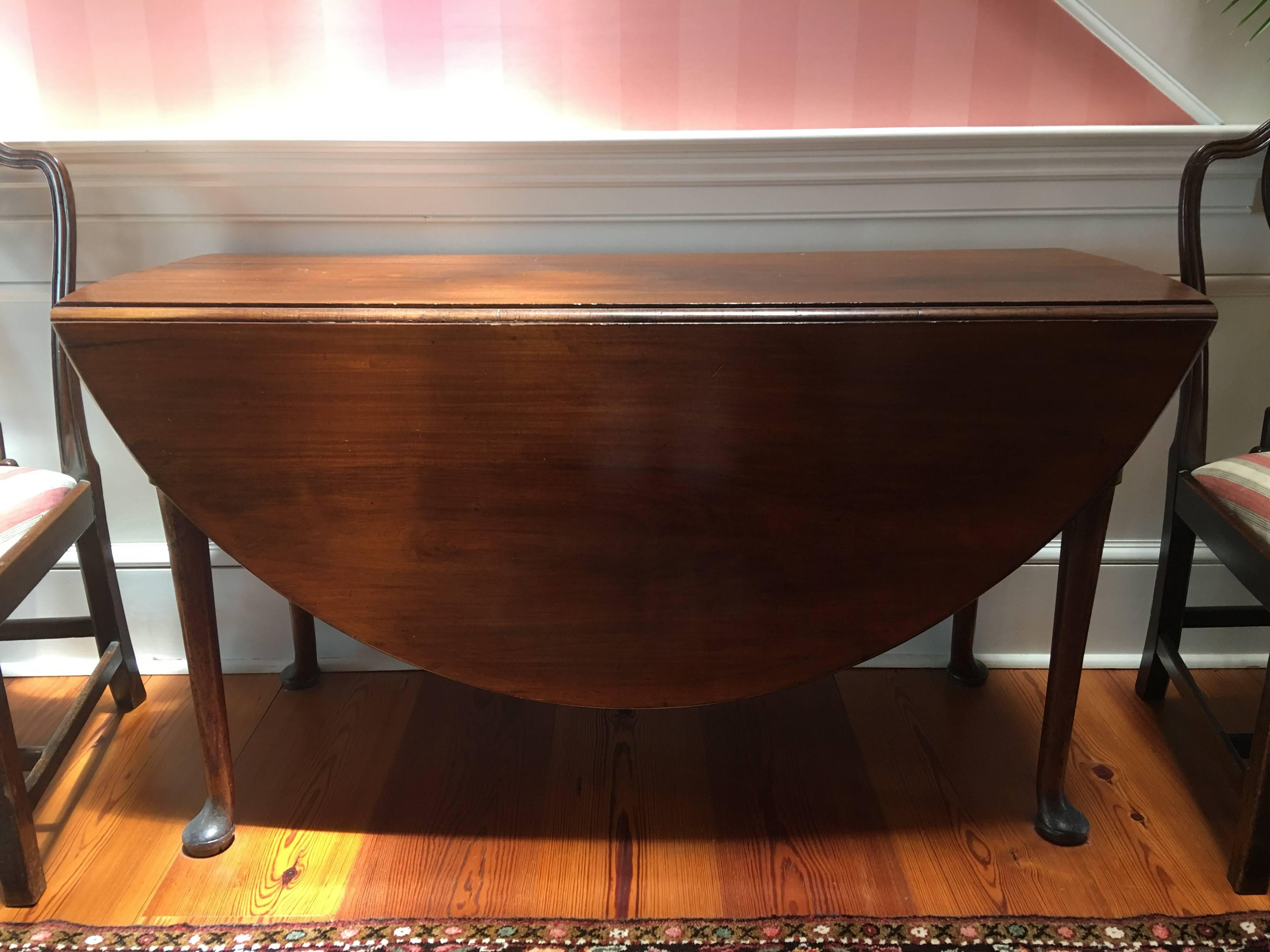 American Queen Anne mahogany oval drop-leaf table with pad feet, mid-18th century. It features a molded oval one inch thick top surmounting a rectangular apron, supported by turned tapering legs terminating in pad feet, swing legs supporting the