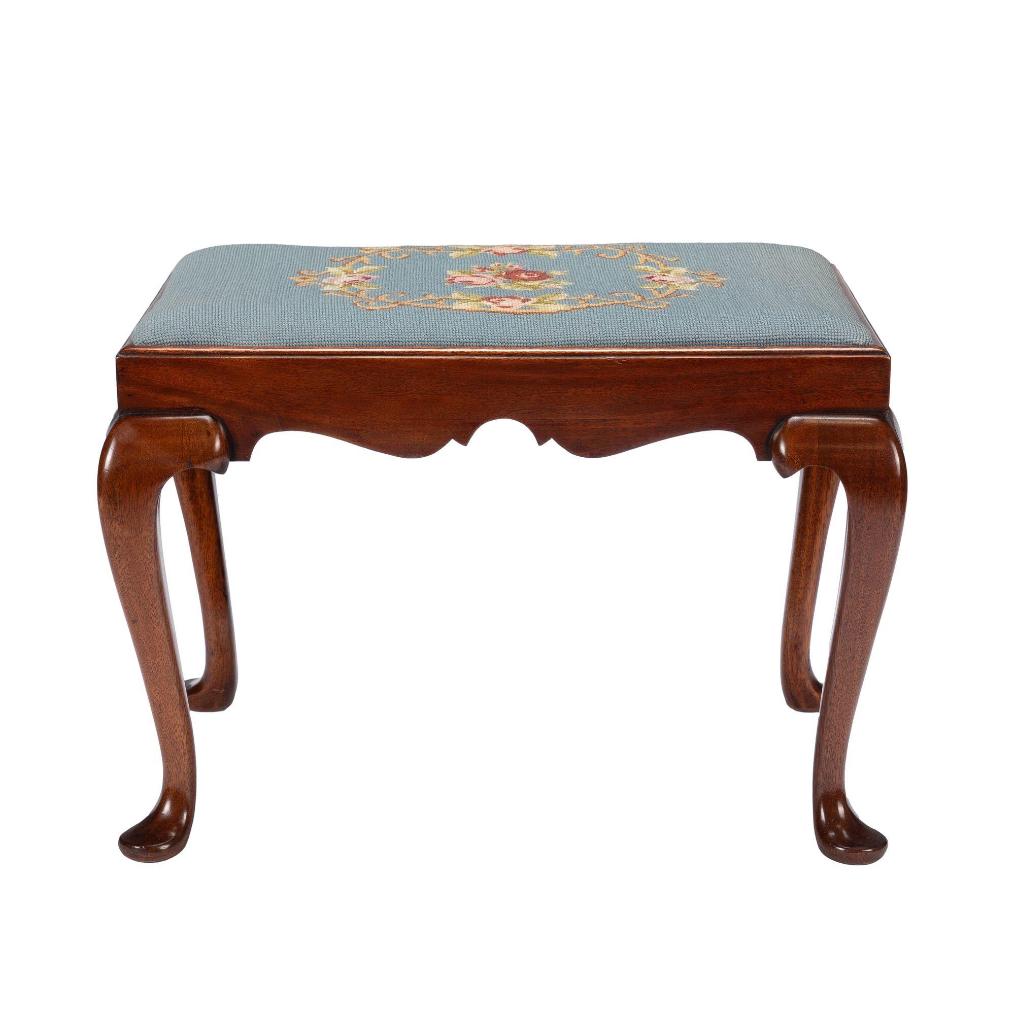 Academic Revival Queen Anne style mahogany bench/stool with upholstered slip seat seat. The cabriole legs flow in a sinuous line from the bowed knee through the rounded and tapered legs which terminate in a flaring pad foot. The legs are morticed