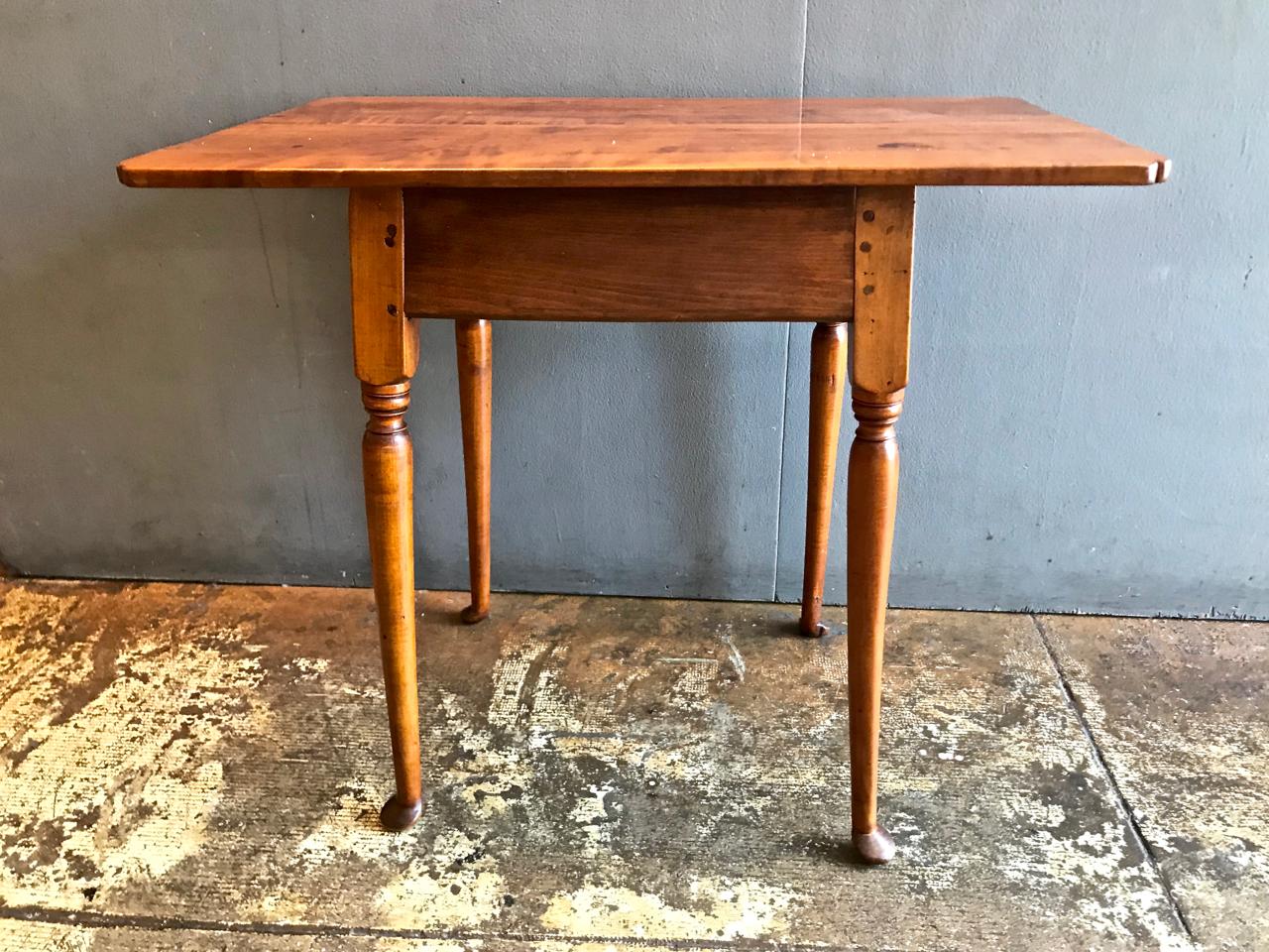 This is a refined example of an 18th century American tiger maple Queen Anne tavern table or side table. The legs are of graceful proportions and end in small pad feet; the inverted table corners add to its elegance. This would make a wonderful