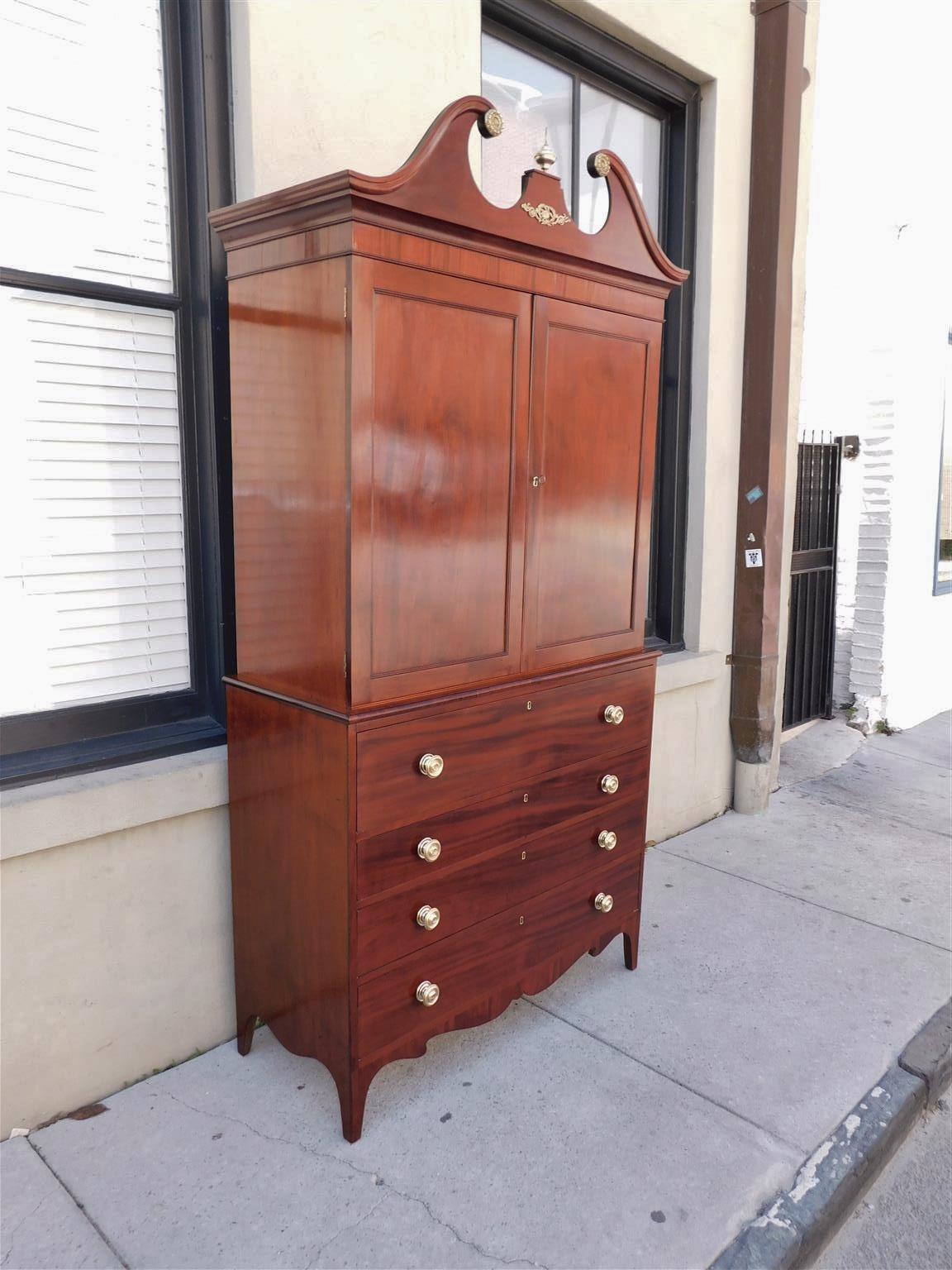 Pressa per biancheria in mogano della Reggenza americana con cornice a collo di cigno intagliata e modanata, urna centrale in ottone ornata da filigrana di cigno ormolu, medaglioni decorativi a fogliame, porte cieche a cerniera affiancate che