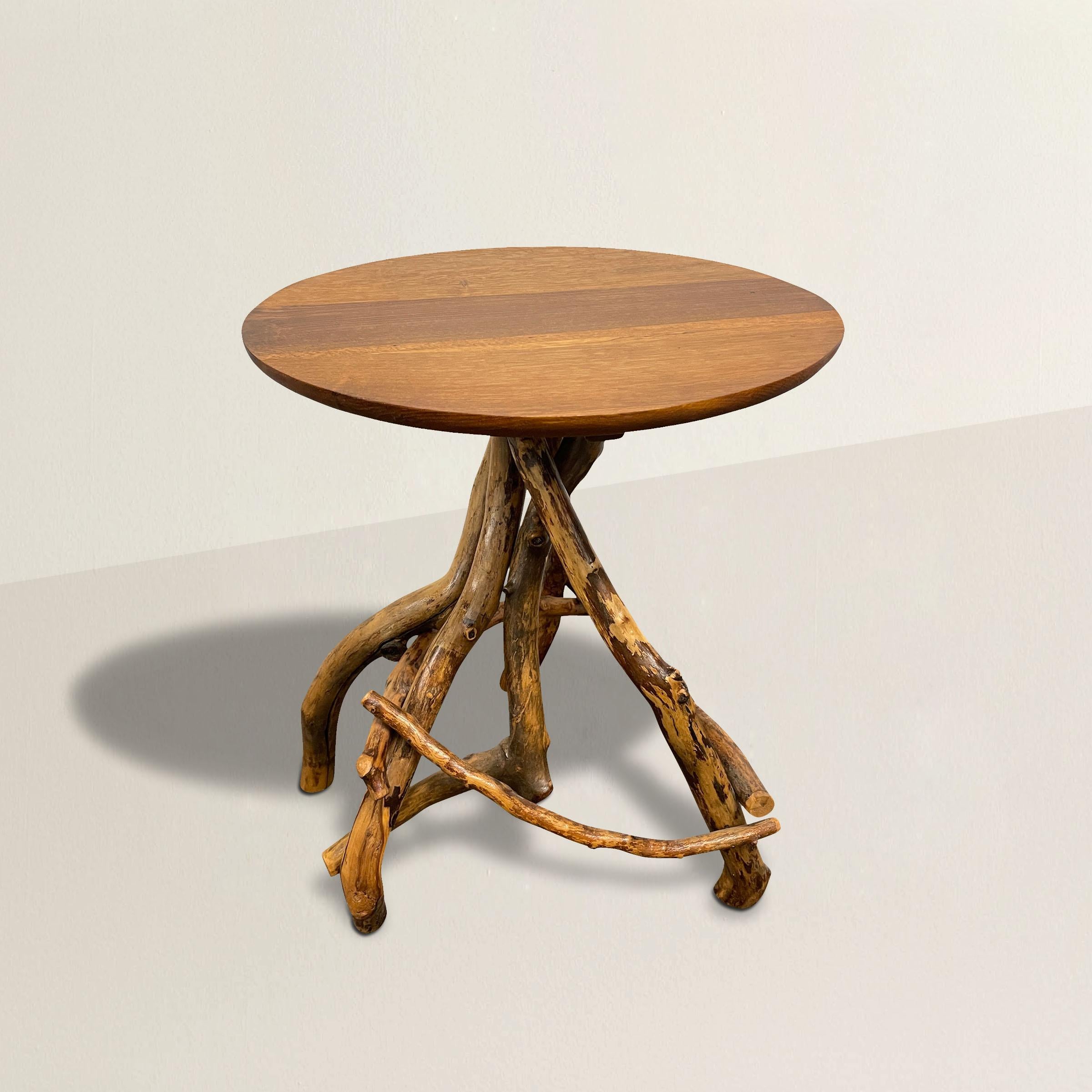 A whimsical 20th century American Adirondack-style rootwood side table with a round oak top, and a base constructed from several gnarly rootwood twigs. The perfect table next to your sofa or favorite reading chair in your cabin.