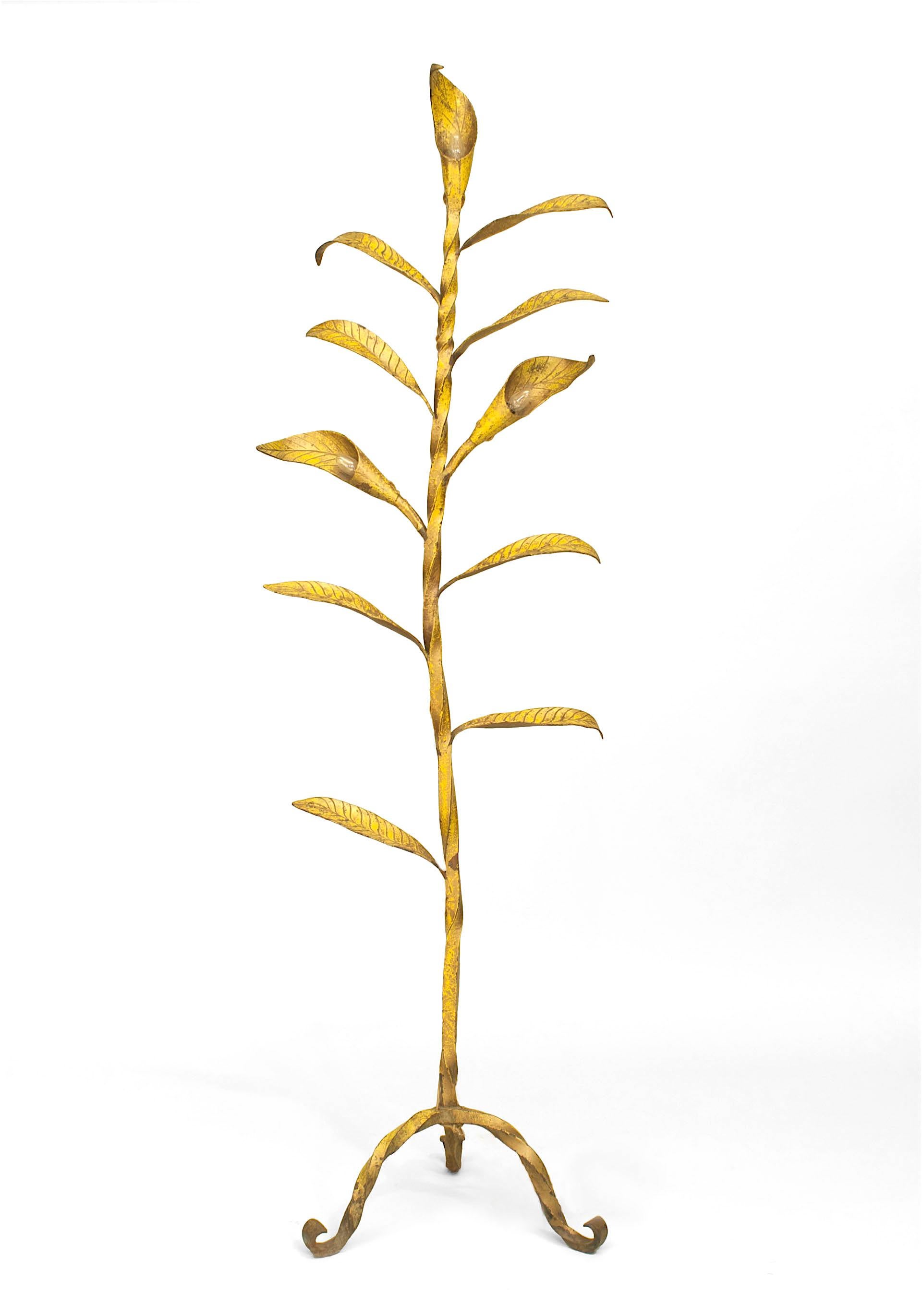 Lampada da terra in metallo verniciato giallo in stile rustico americano (anni '20 circa) a 11 foglie con 3 luci che emanano da una struttura in ferro ritorto che poggia su una base a 3 gambe.

