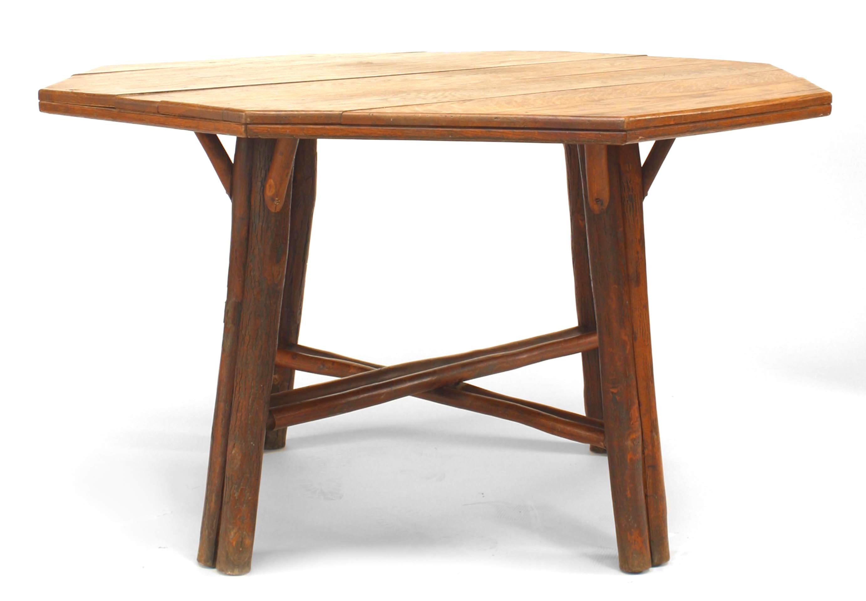 American rustic dining table with an octagonal oak plank top above four double legs united by an intersecting stretcher. Branded 