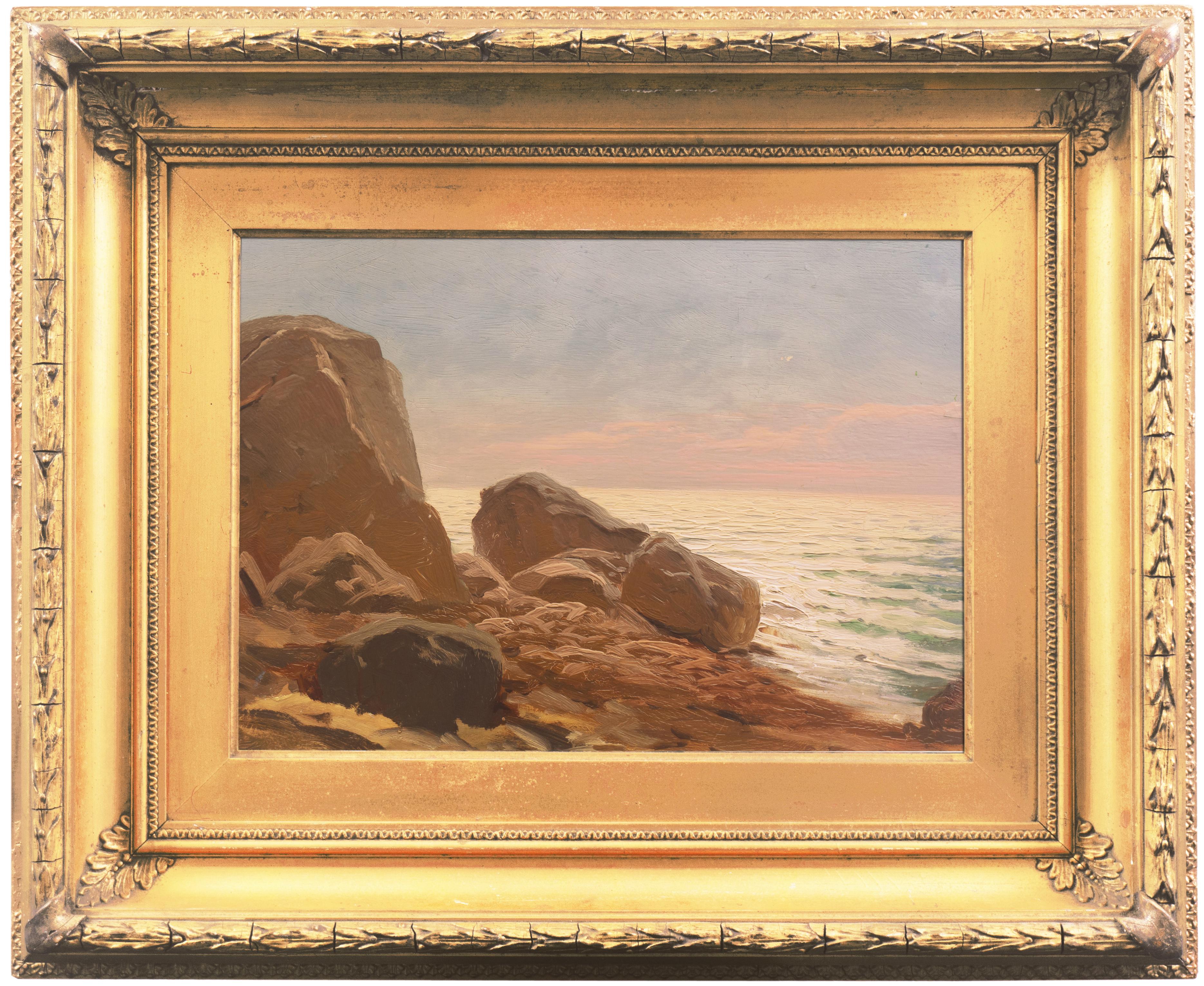 A late 19th century, American School seascape showing a lyrical view of sunlit waves flowing in towards a rocky beach. The unknown artist shows exceptionally sensitive handling of light in the interplay of sky and water and suitable gravitas in the