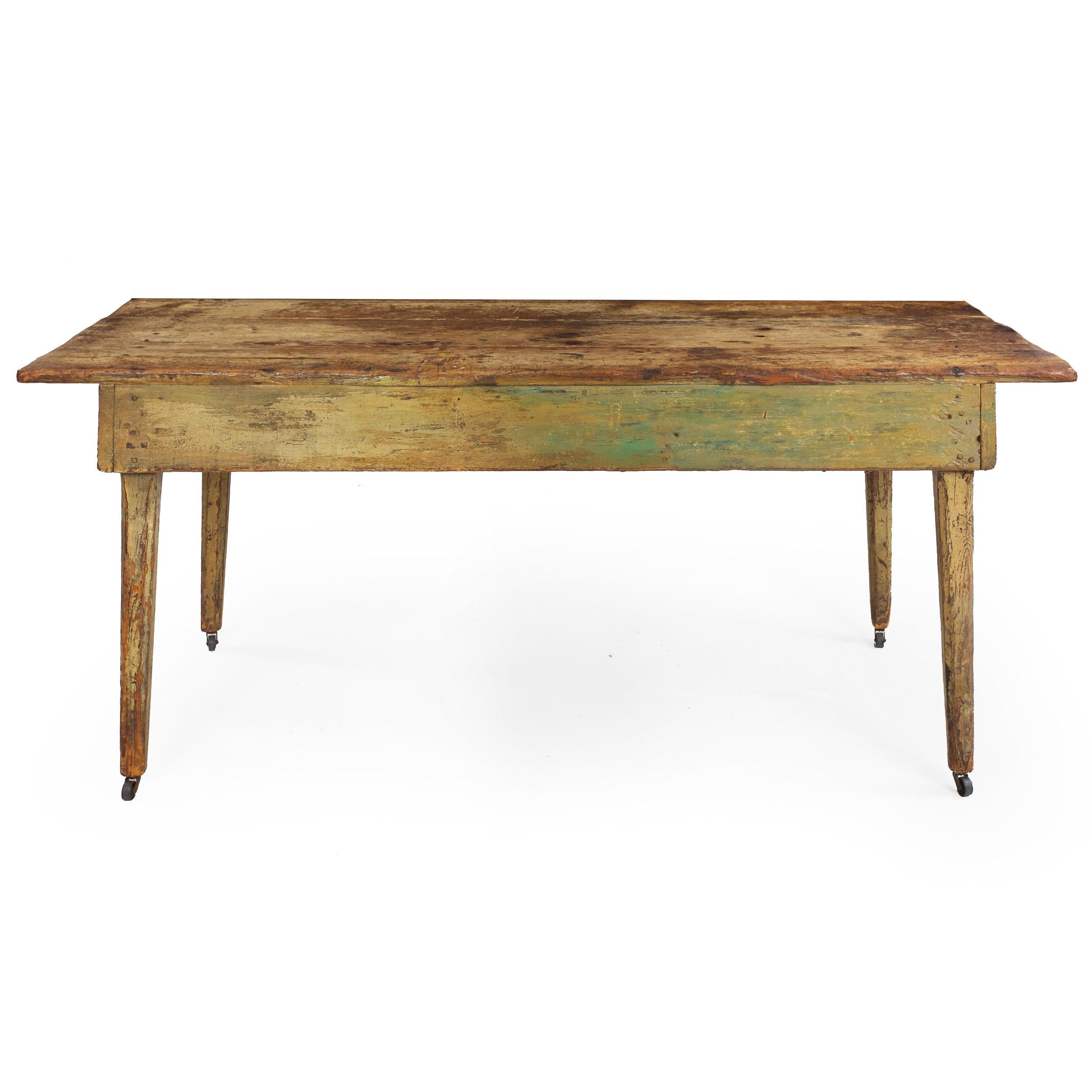 A wonderful scrubbed pine preparation table for the kitchen spaces, it features three positively broad pine planks for the top with an absolutely gorgeous patina throughout. They exhibit a fine historical surface with old knife cut marks, stains and