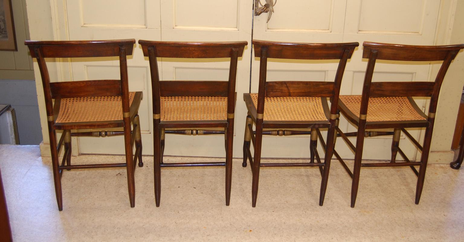   American Mid 19th Century grain painted set of four cane seated two slat side chairs of Hitchcock design.  The hand painted grain painting is superb and the legs have ring turnings  which are highlighted in gold.  There is a subtle gold line to