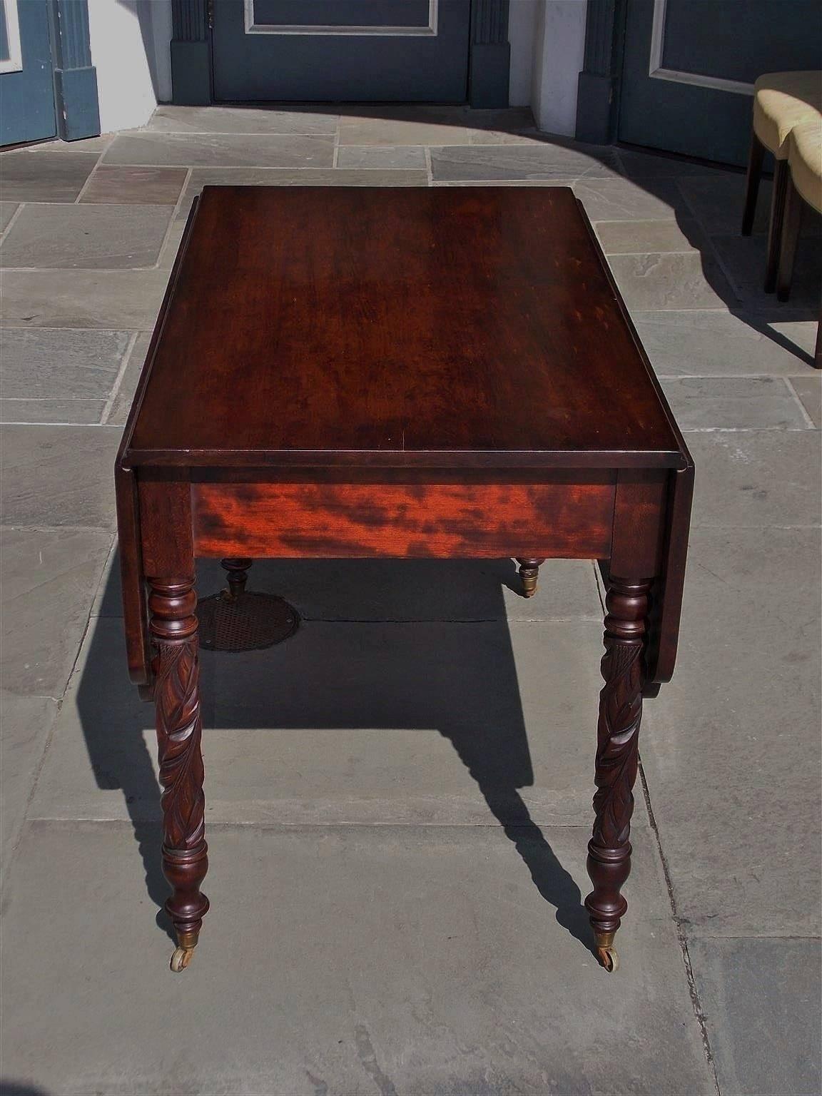 American Sheraton cherry table with a one board top, two scalloped drop leaves consisting of one board, triangular interior supports, and terminating on acanthus carved legs with the original brass casters, Early 19th century
Measure: Table is 51.75