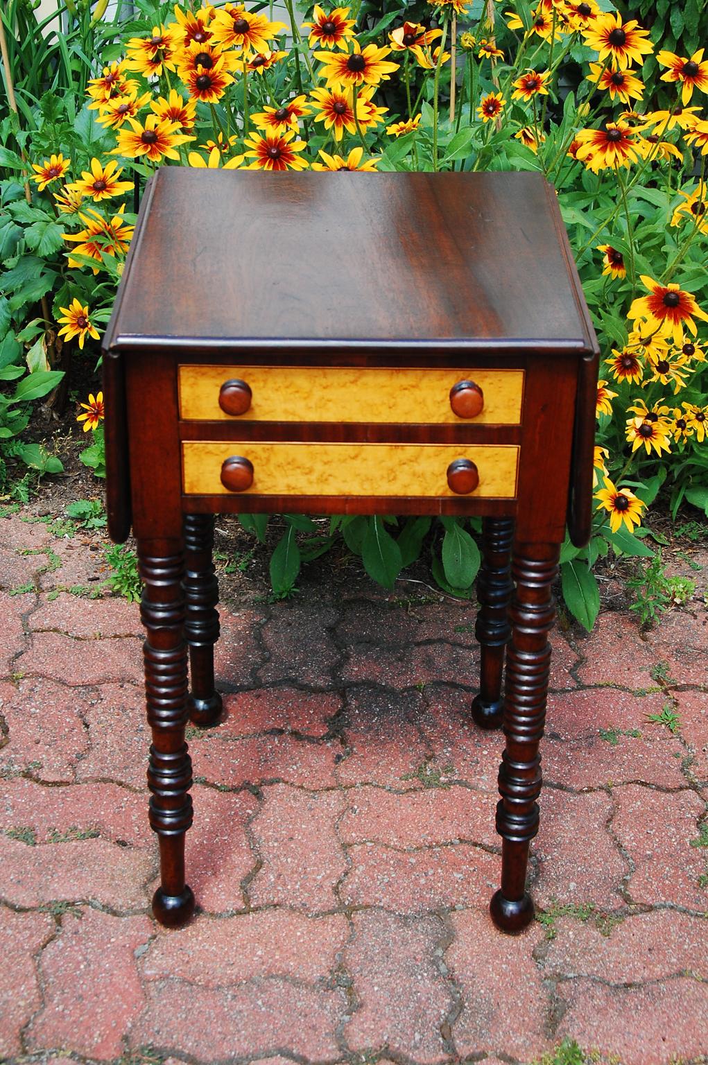 American Sheraton dropleaf mahogany two drawer worktable with birdseye maple drawer fronts and original mahogany turned knobs. This country table continues the Sheraton gestalt with somewhat bolder ring turnings to the legs than would have been done