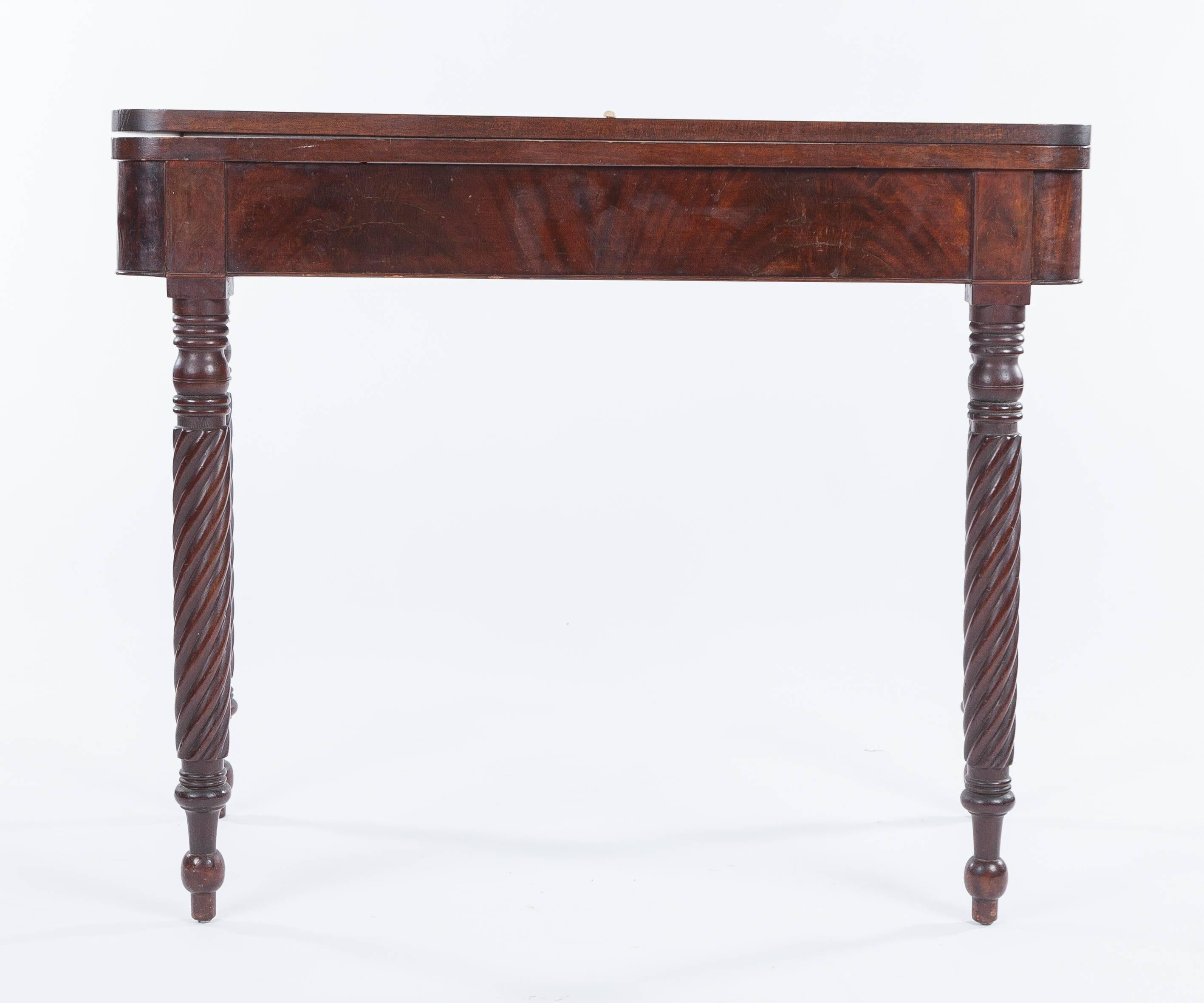 An American Sheraton card table dating to circa 1840. Made of mahogany and featuring spiral turned legs. The card table measures approximately 36