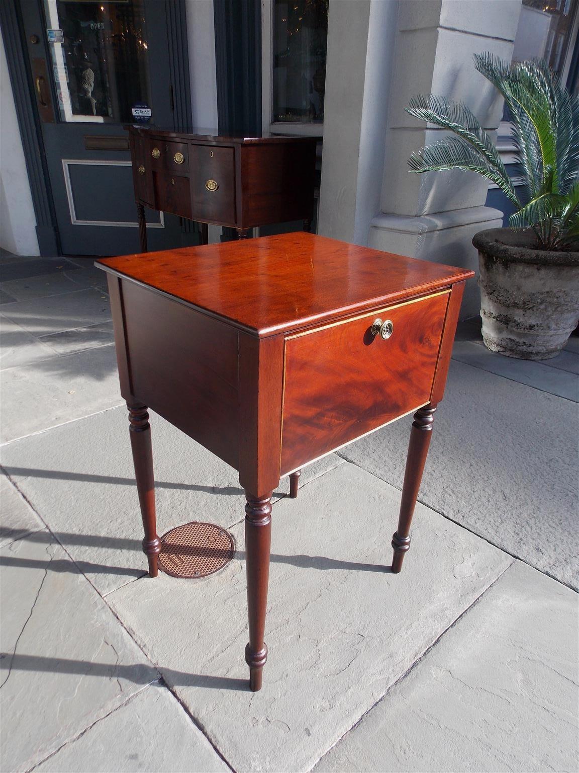 American Sheraton mahogany hinged side table with a carved molded edge top, centered floral brass, and terminating on the original turned bulbous legs. Secondary wood consist of white pine. Early 19th century.