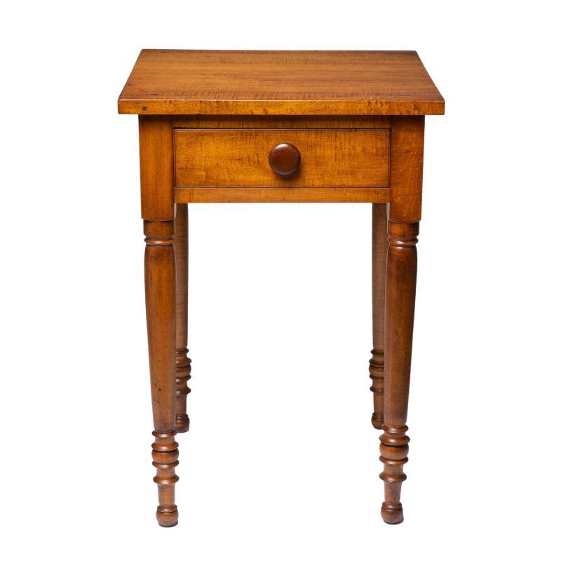 American Sheraton maple one drawer stand fitted with a single mushroom turned knob. The legs are crisply turned with fine ring turnings terminating in a button foot.

American, Northern New England, circa 1830.