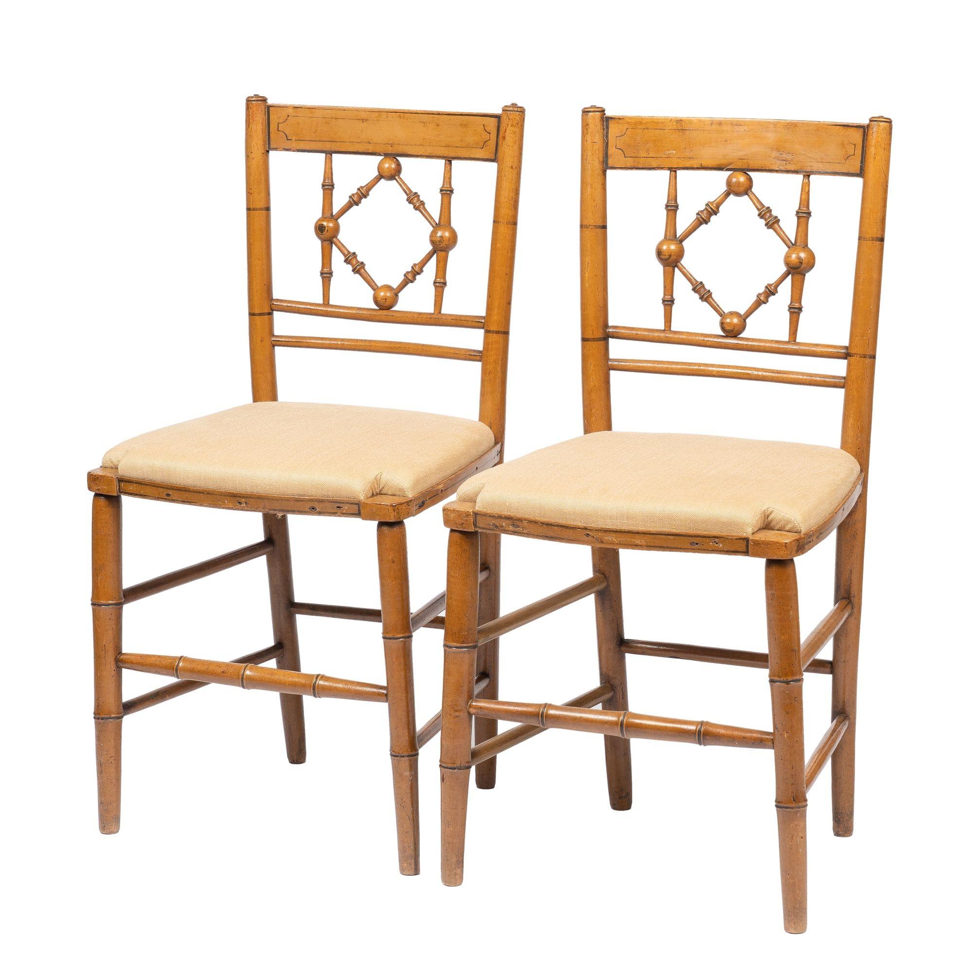 Pair of Sheraton mustard painted hard wood fancy chairs with black stripping. The rush seat frames have been refitted with upholstery.
American, Middle Atlantic, circa 1800.
 
Dimensions: 16-1/2” W x 17” D x 33” H
18-1/2” (seat height)
14-1/2”