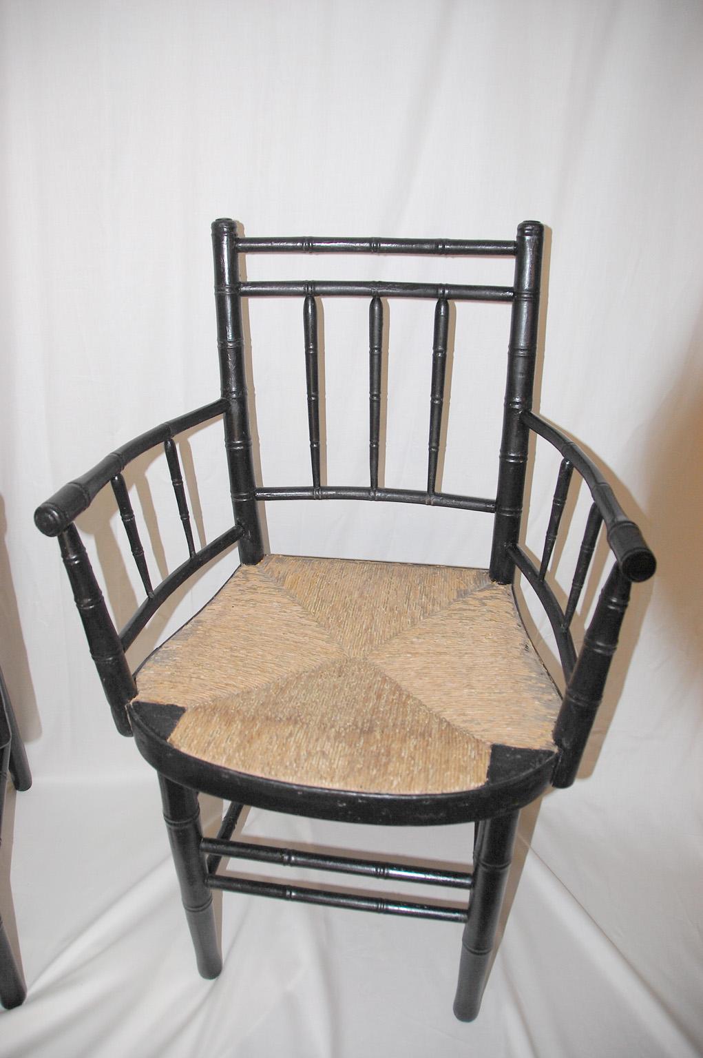 American Sheraton period pair of painted armchairs. These quintessential American chairs have original ballooned rush seats, bamboo turnings, double box stretchers, turned and bowed arms. The chairs have been recently repainted. Circa 1810.