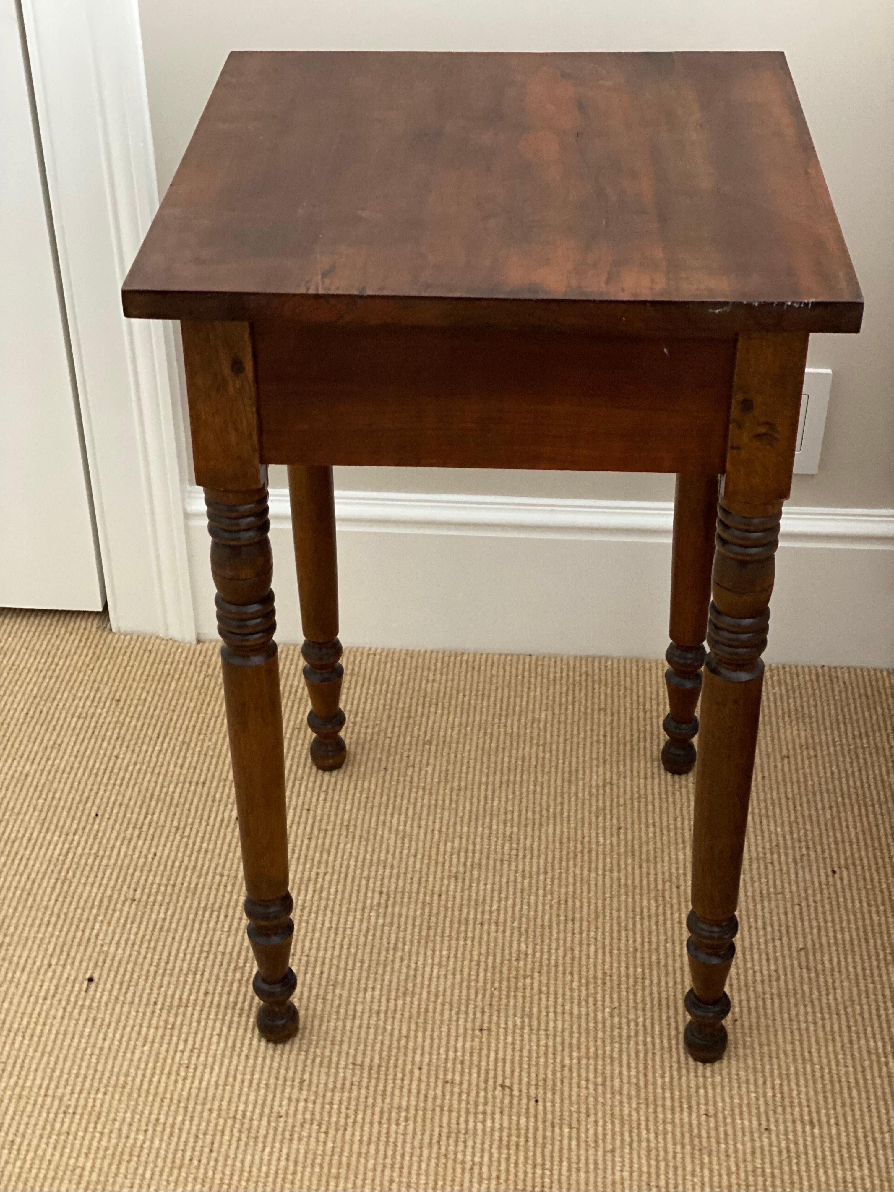 American Sheraton single drawer maple stand, 19th century.
A single drawer stand made of maple with finely turned legs ending on bun feet and a porcelain knob. General wear, good overall condition.

Measures: 18